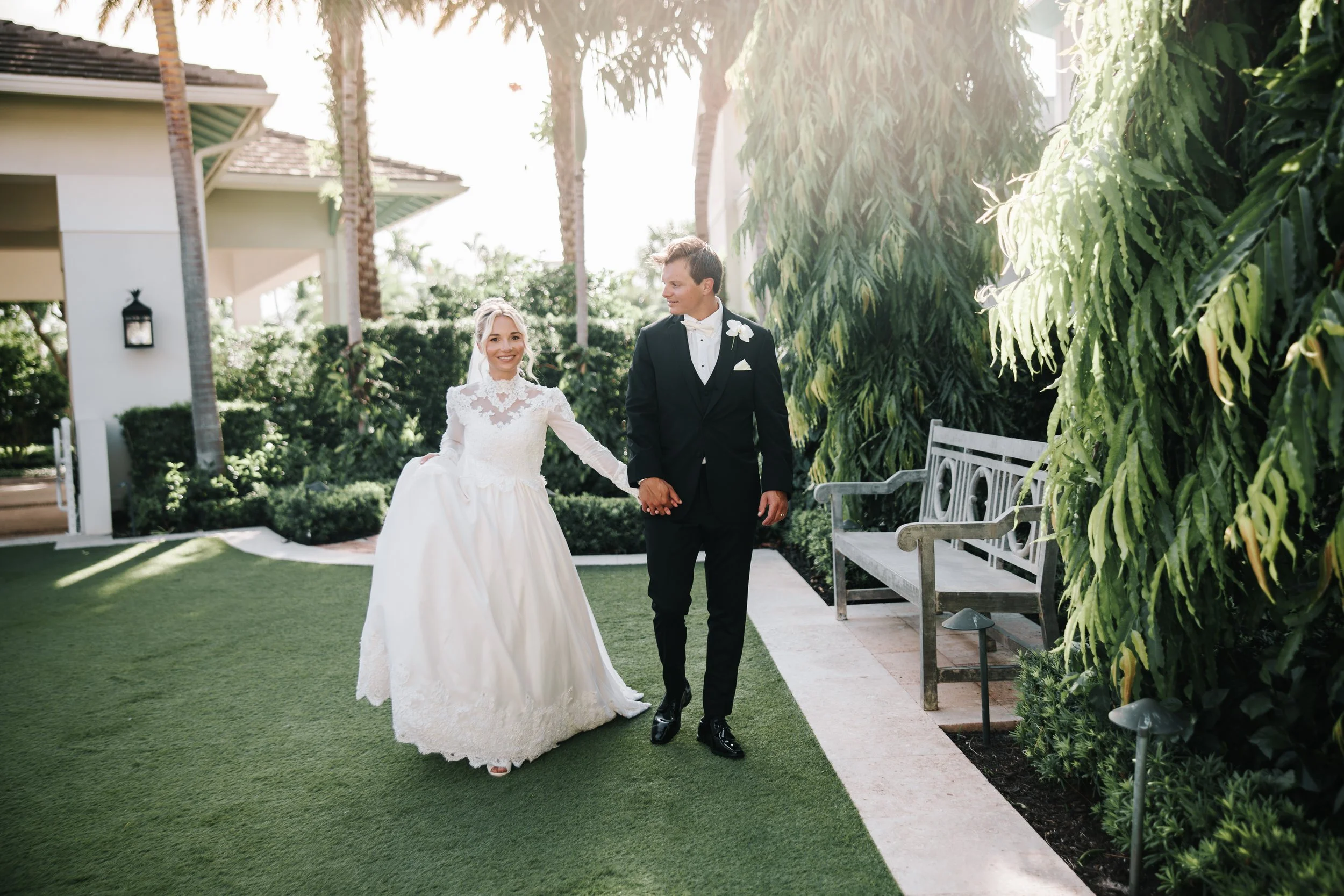 Couple walking through tropical garden at wedding