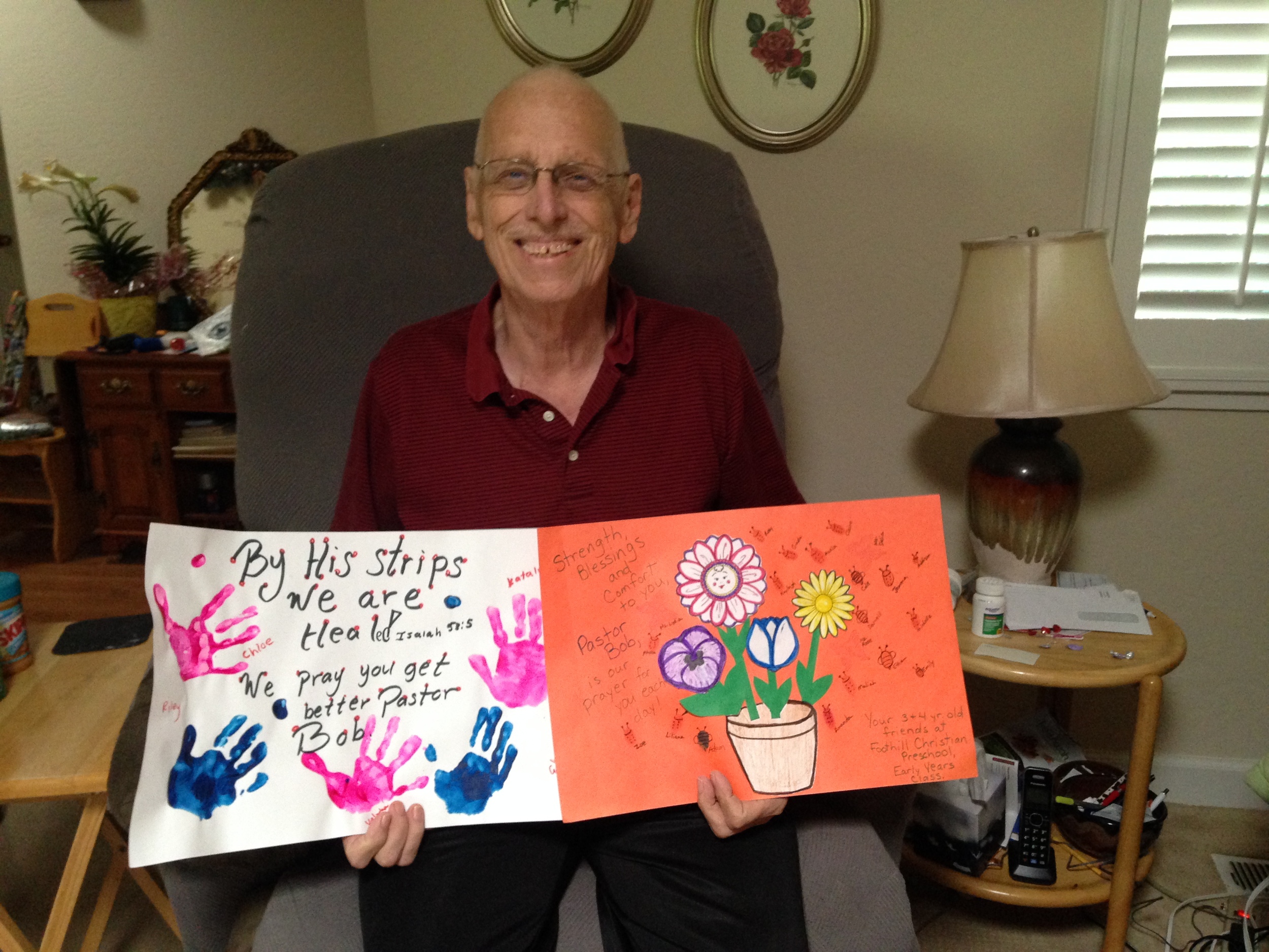 Pastor Bob, at home, holding cards that were made for him by the children of Foothill Christian Preschool