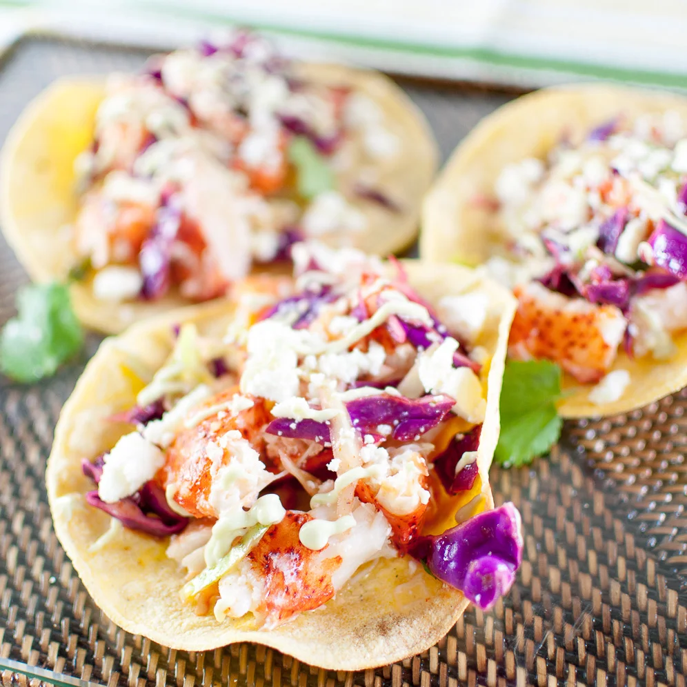 lobster tacos with chili-lime slaw and avocado crema