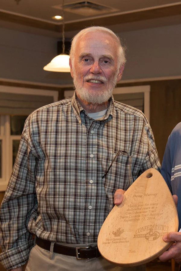 Doug Murray being presented with a maple cutting board engraved with the words: “Thank you for your many dedicated years as a Confederation Trail/Trans Canada Trail builder,” during a celebration marking the full connection of P.E.I.’s portion of the Trans Canada Trail on September 12, 2014. Photo: Louise Vessey
