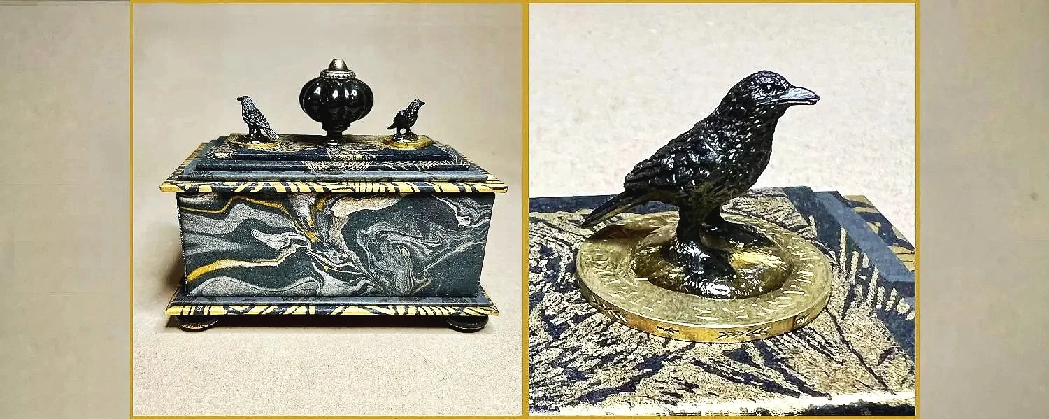 A Gift or Treasure  Box in Black and Gold with two Crows Atop