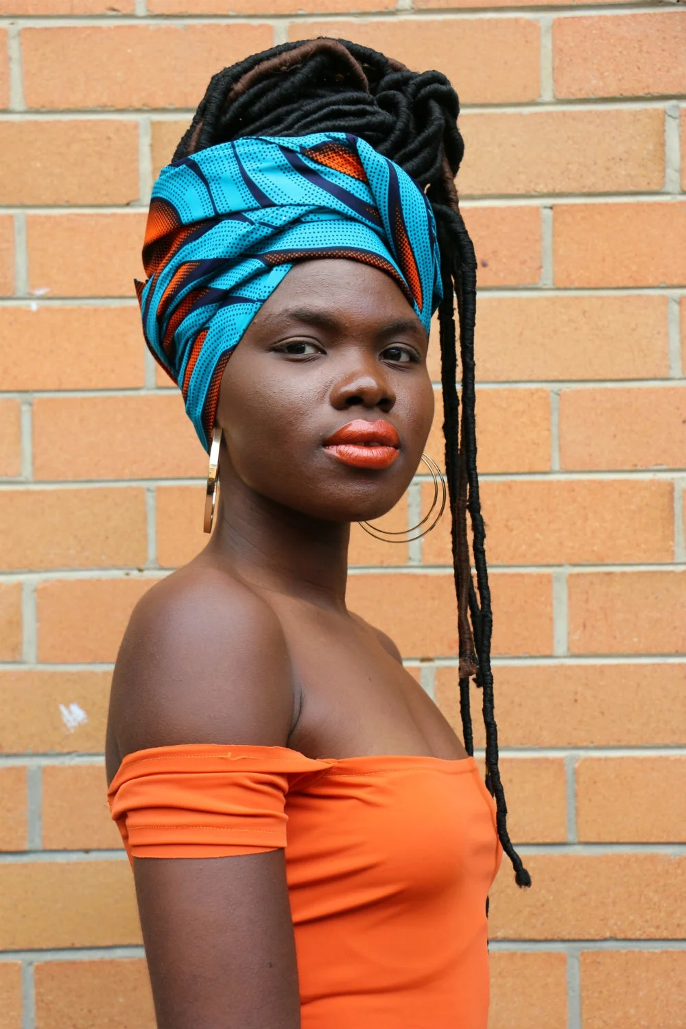 Leaving a few of Mariama's braids outside headwrap ANIKA added to the casual look we were aiming for and highlighted the intricate and painstaking workmanship that goes into creating this magnificent hairdo.