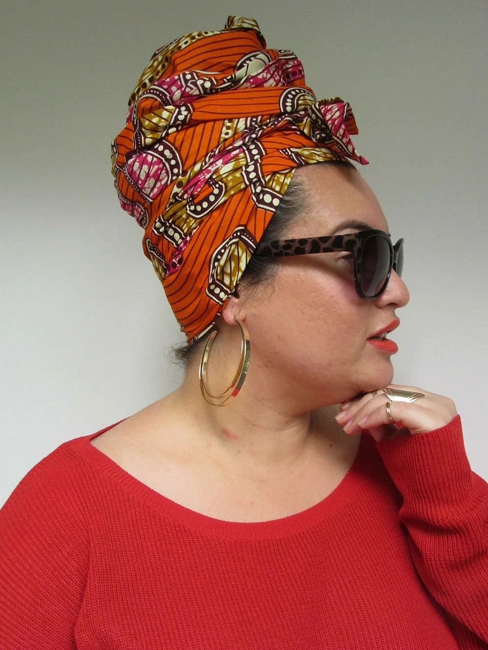 Styling for headwrap MACY consisted of the TURBAN. Instead of tucking in the loose fabric ends, we used these to tie a small side bow. Gold rings and hoops complete the look.
