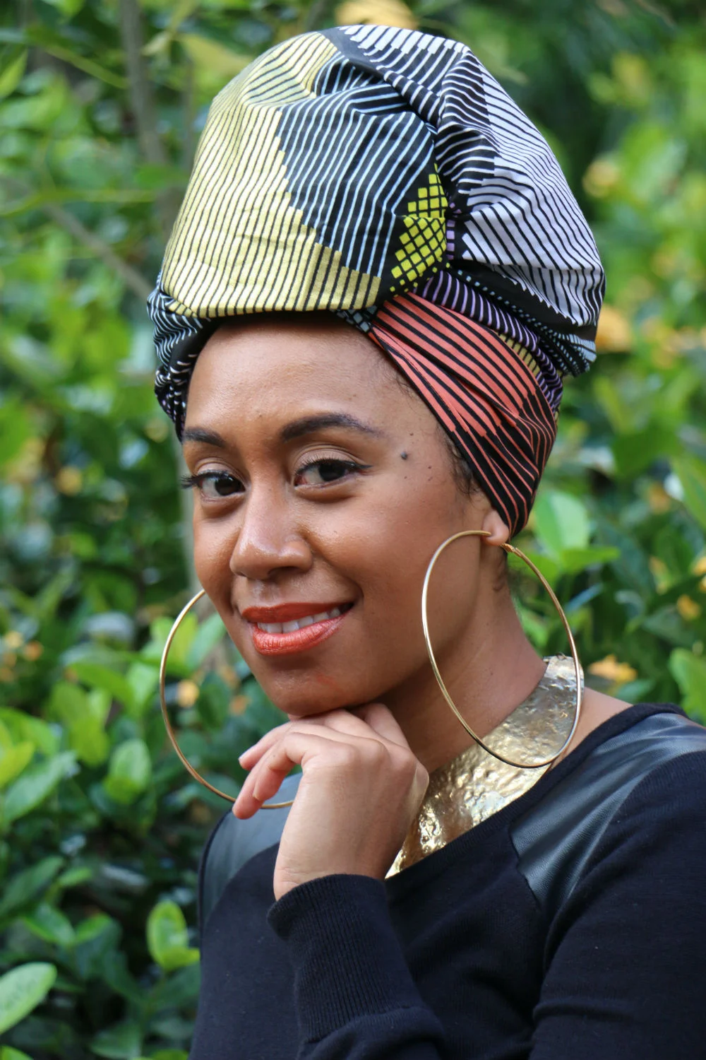 Oversized gold hoops, a solid gold choker, orange lippie and black eyeliner highlighted the warm colour palette in headwrap TARAJI.