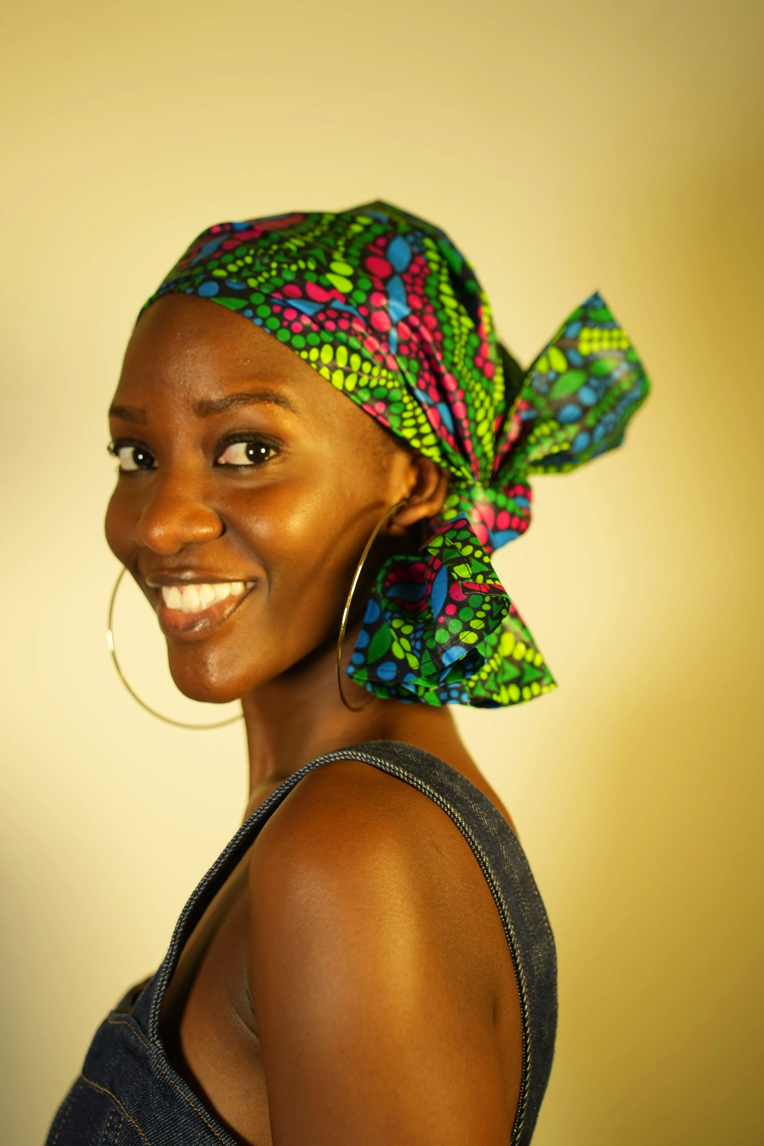 Woman smiling and wearing a headwrap