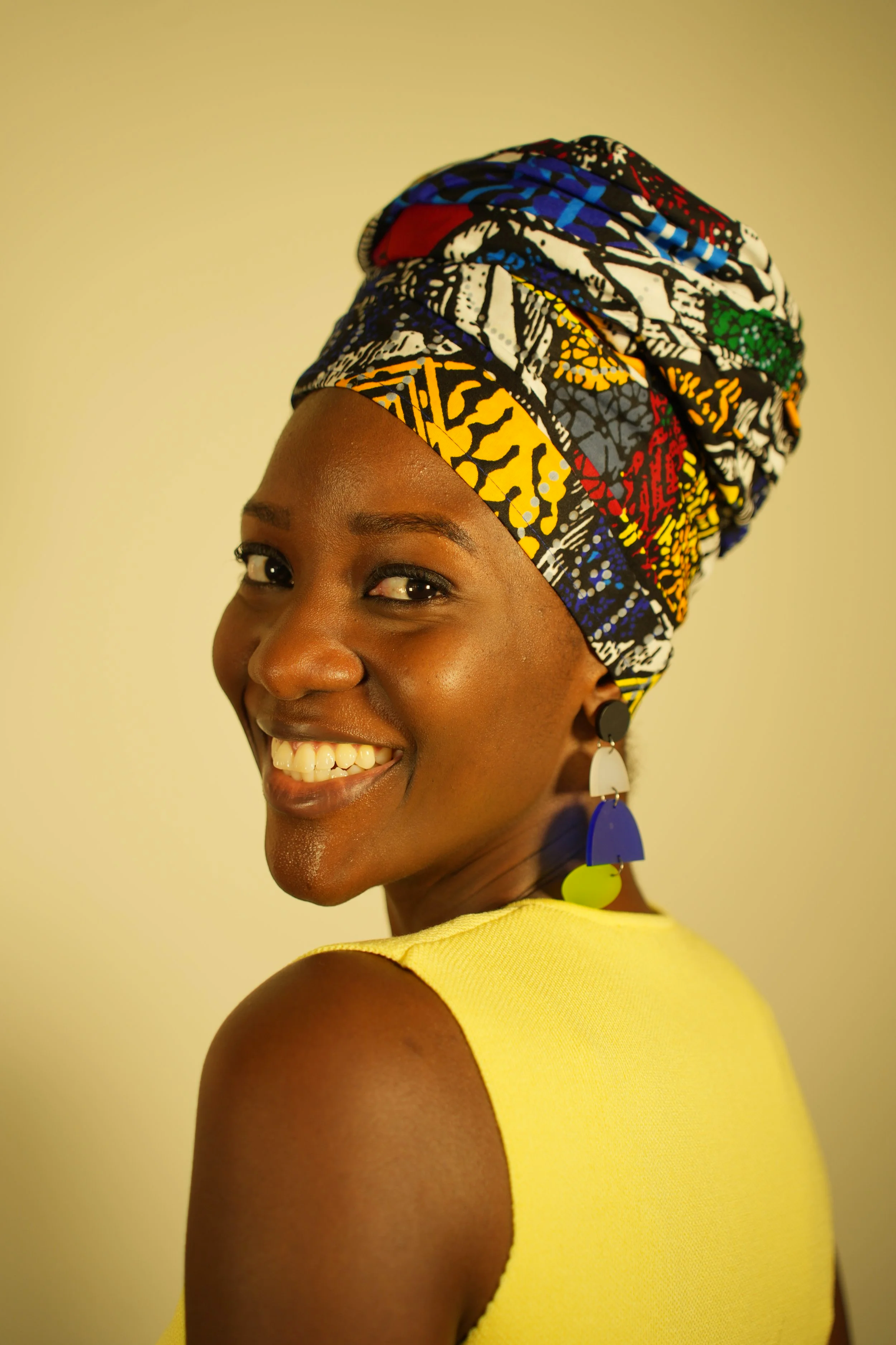 Woman smiling and wearing a headwrap
