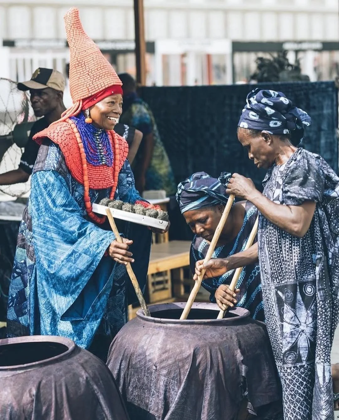 A group of women dressed in traditional attire dying fabric