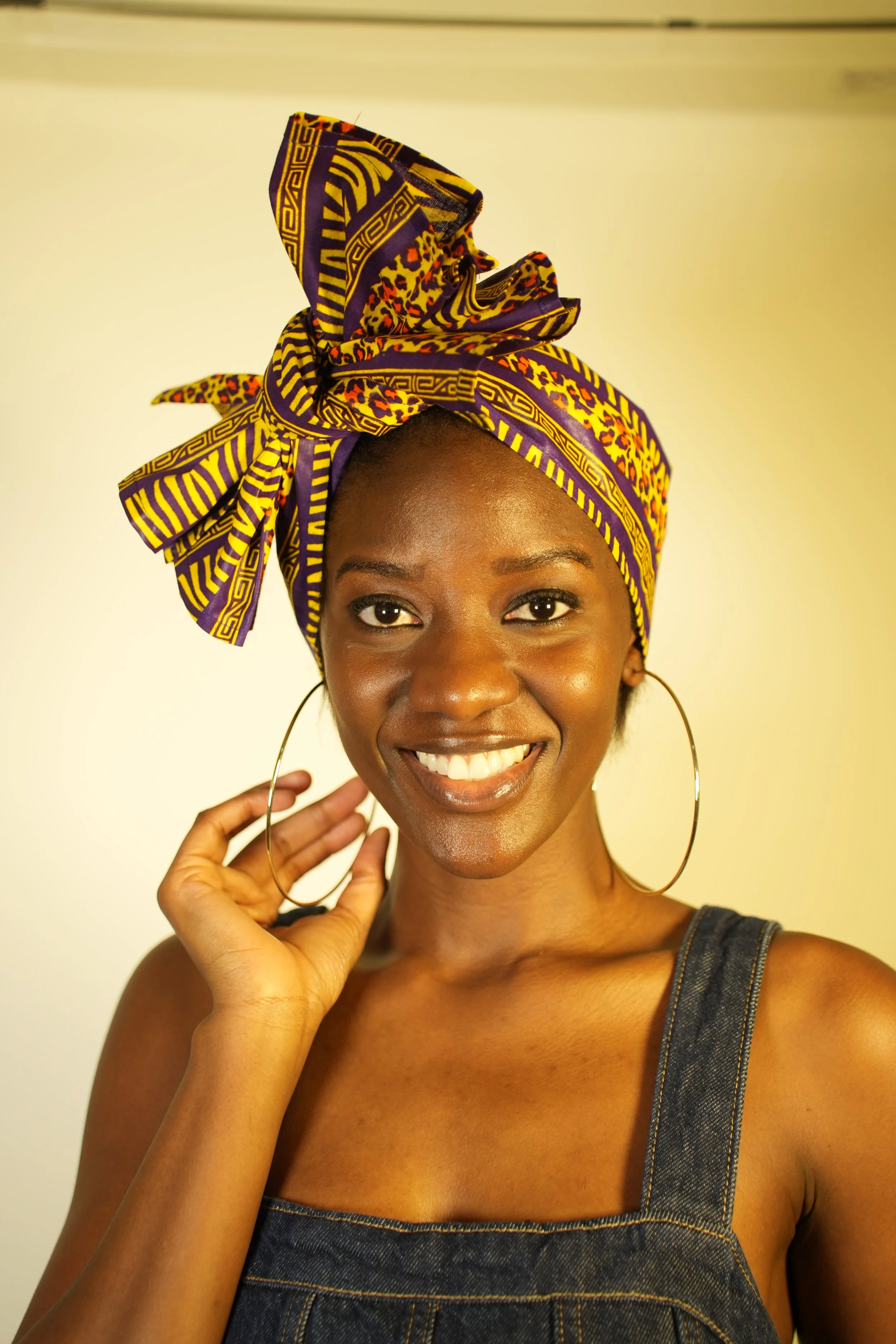 Woman smiling and wearing a headwrap