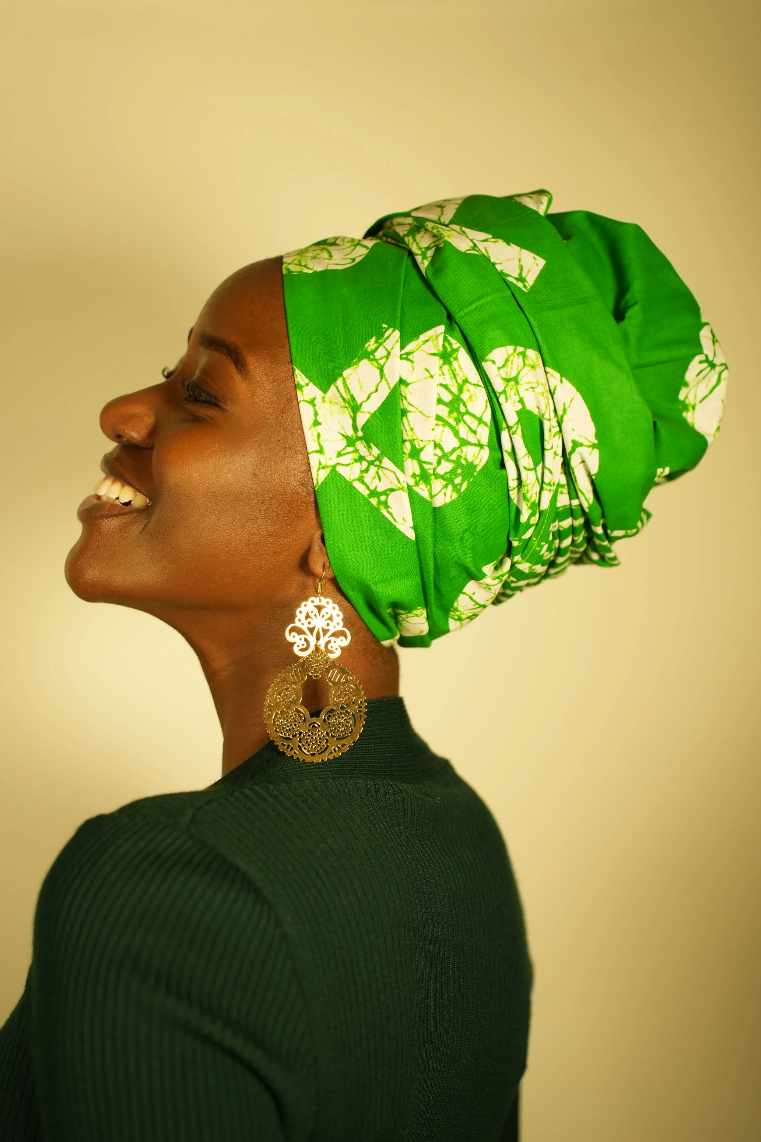 Woman smiling and wearing a headwrap