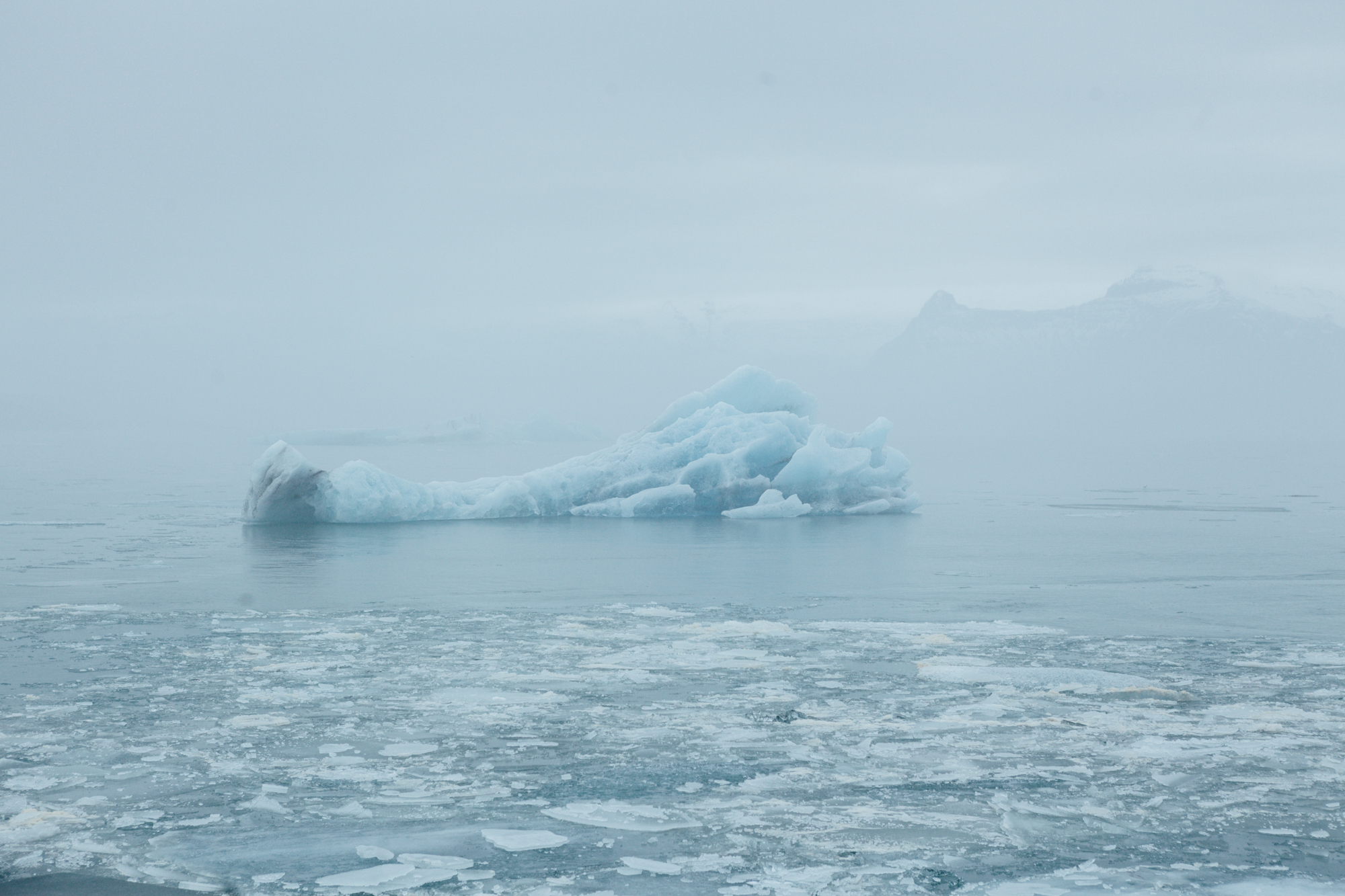  This is our first image from Jökulsárlón (glacier lagoon). The lagoon drains into the Atlantic and contains icebergs and water from the surrounding Breiðamerkurjökull glacier. The blue glacial water and overcast skies made for a surreal experience h