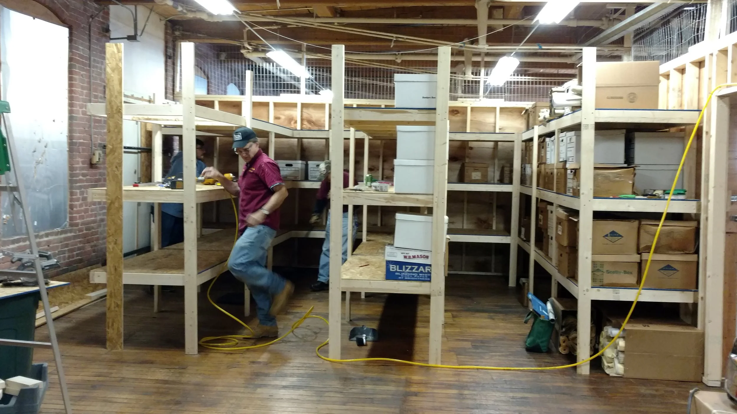 March 20, 2018. Jim Nigzus builds additional shelving. Many boxes have already been moved into the new space by Jimmy Nigzus, Rick Kfoury, Richard Nichols, and Tim Hairston. Staff photo
