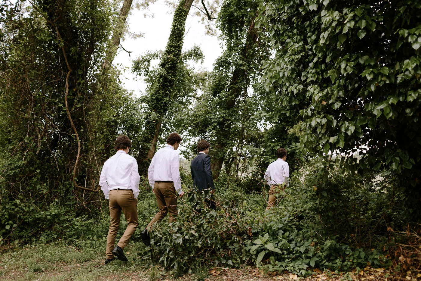 Groomsmen walking through woods