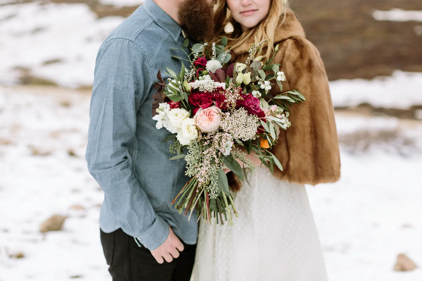 Bride and groom on mountain with flowers