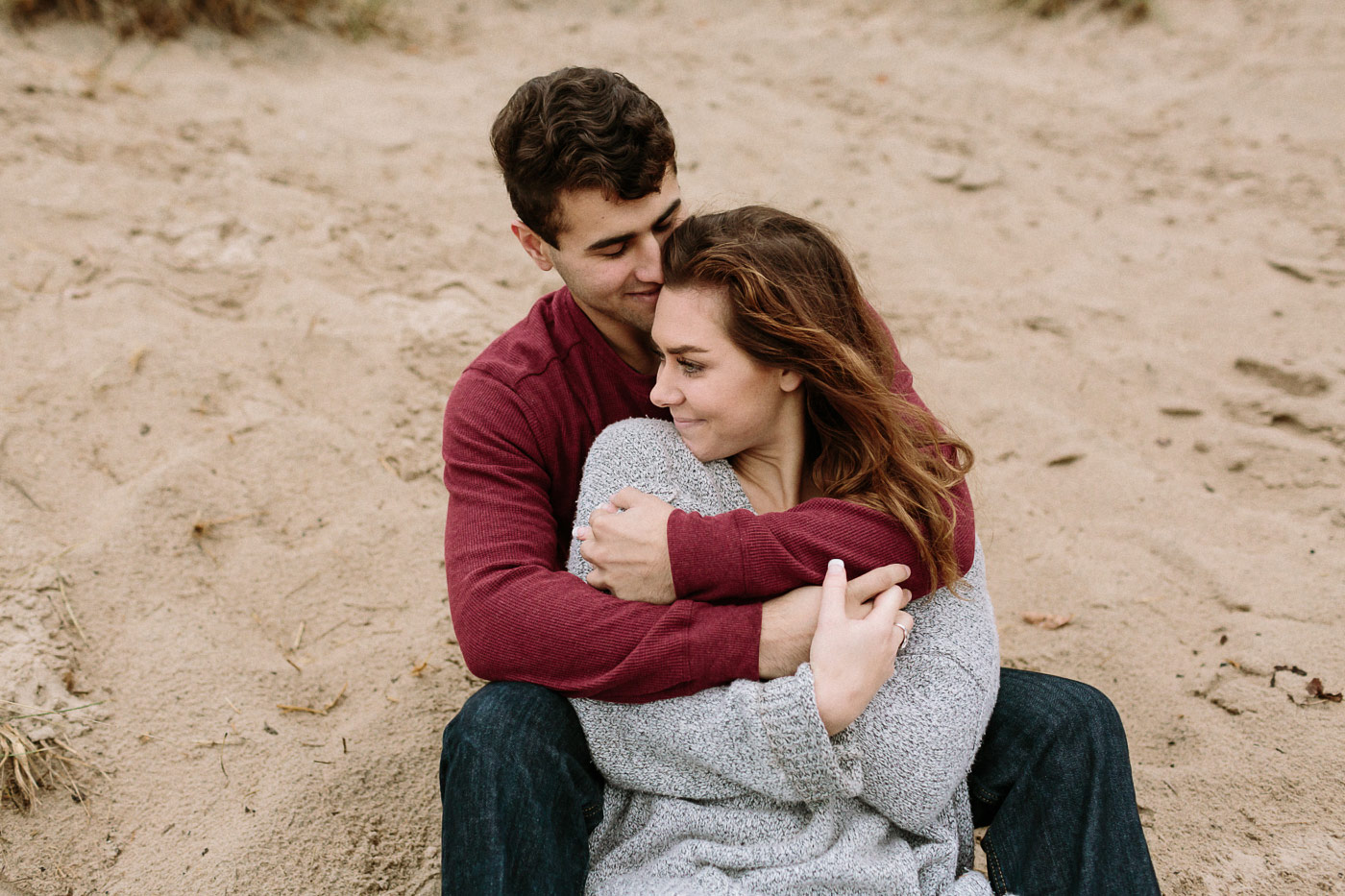 Couple hugging sitting in the sand