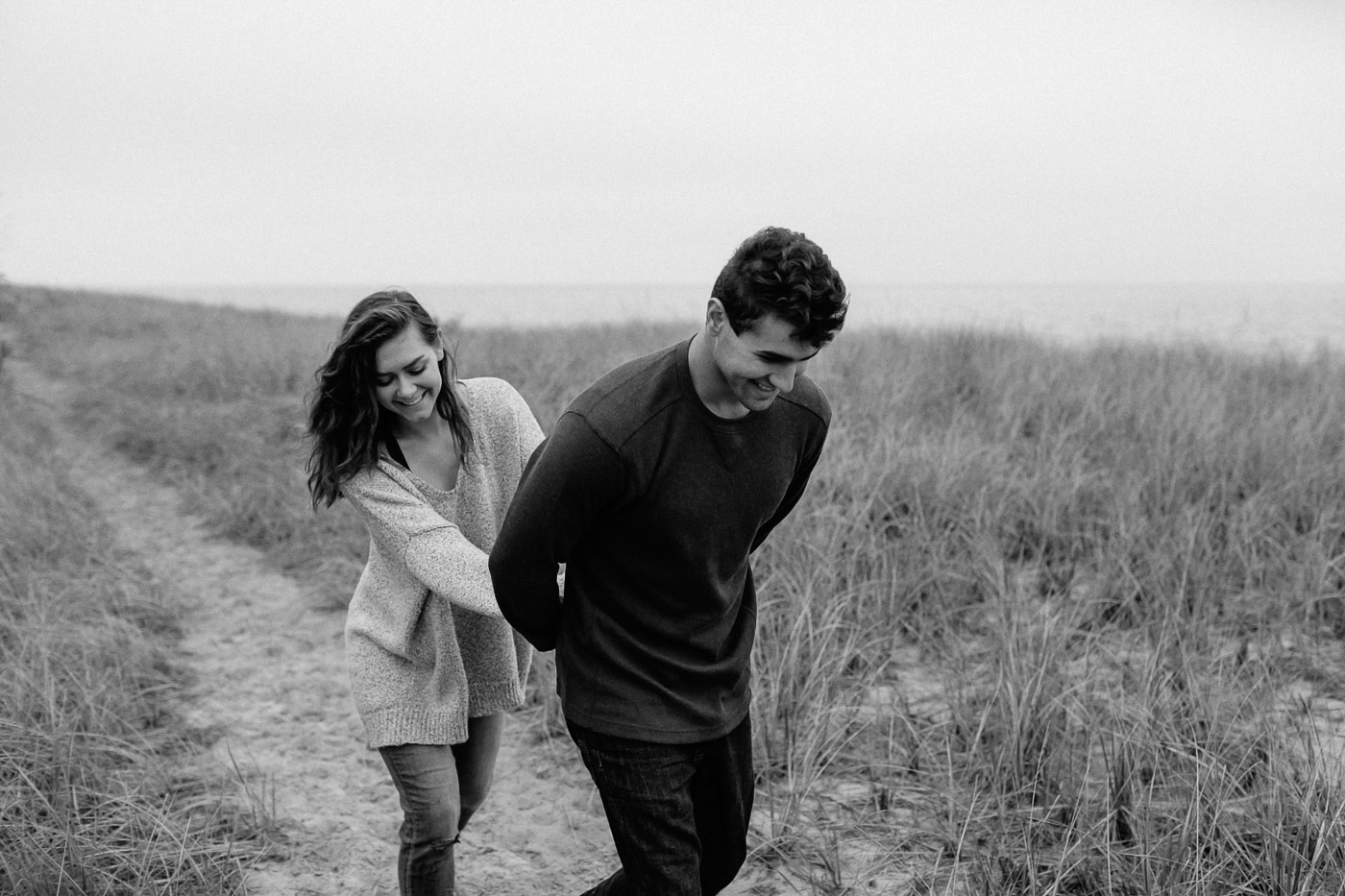 Couple walking and laughing along beach path