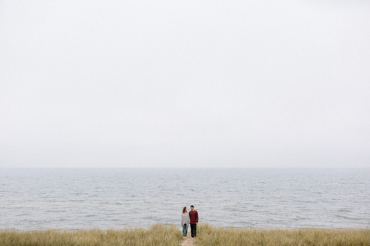 Girl and guy standing on beach beside Lake Michigan