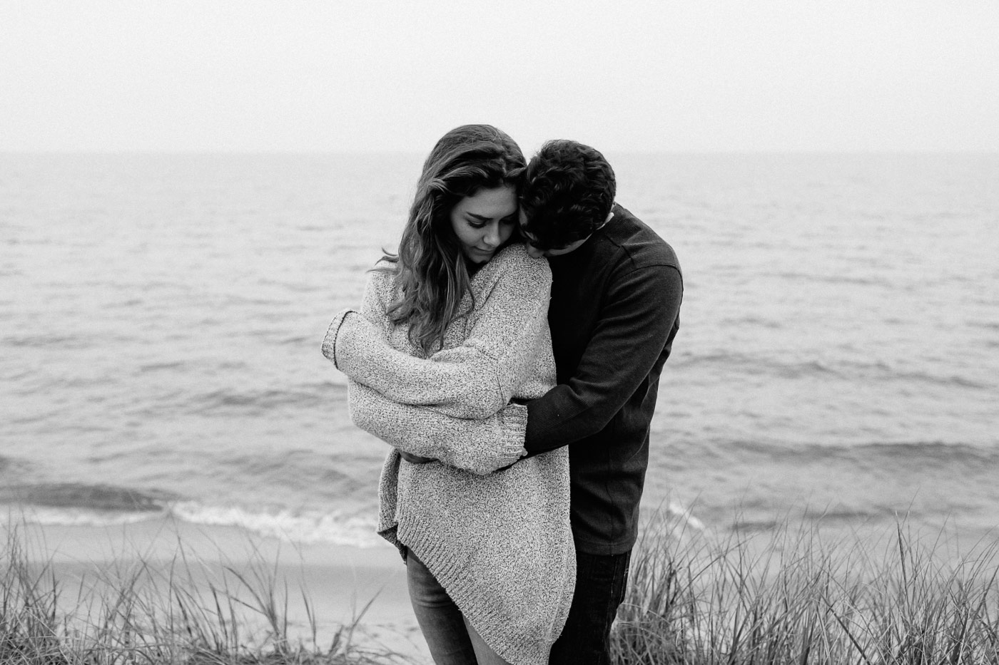 Guy kissing girls shoulder at the beach