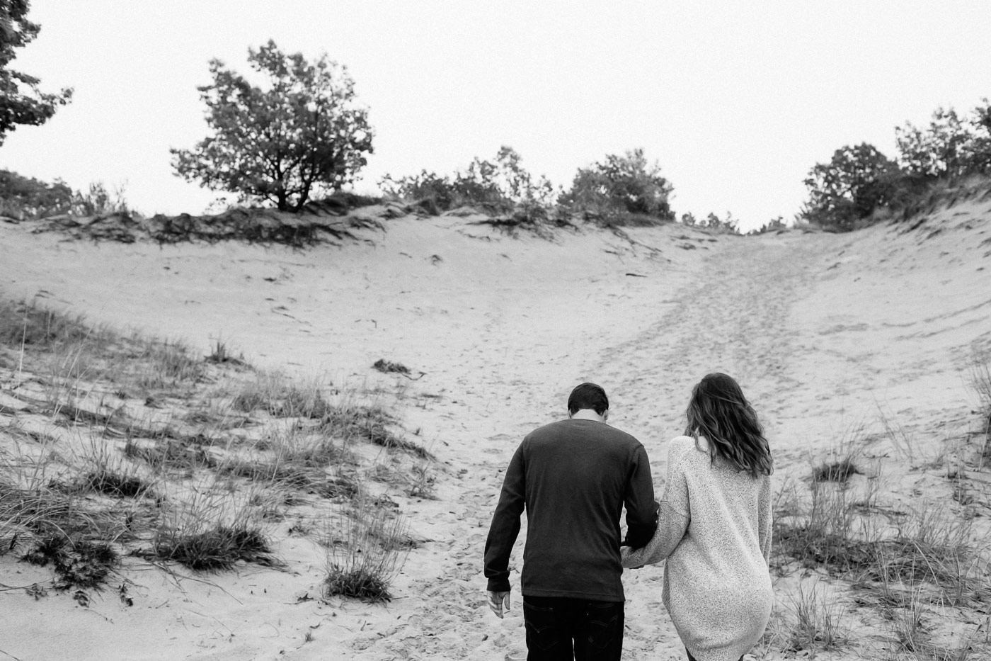 Couple walking up dunes