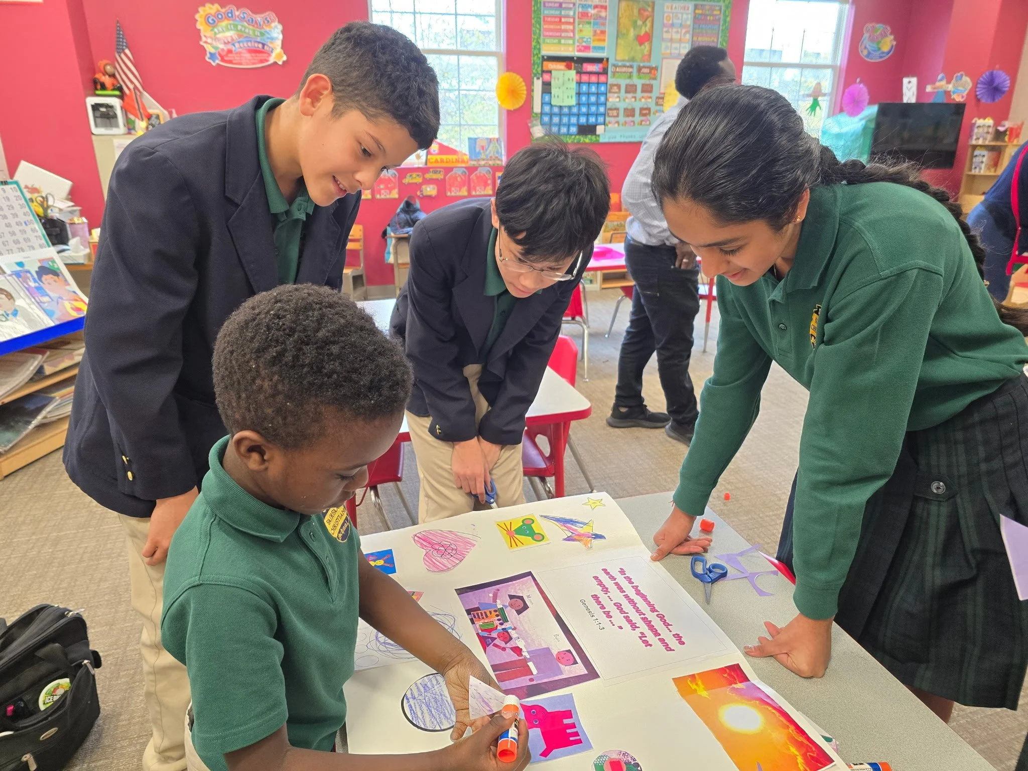 A diverse group of students working on a project together at a classroom table, with colorful decorations and educational materials in the background.