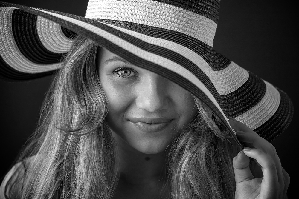 Zwartwit portret van vrouw met hoed in studio in Loosdrecht professionele fashionfotografie.jpg