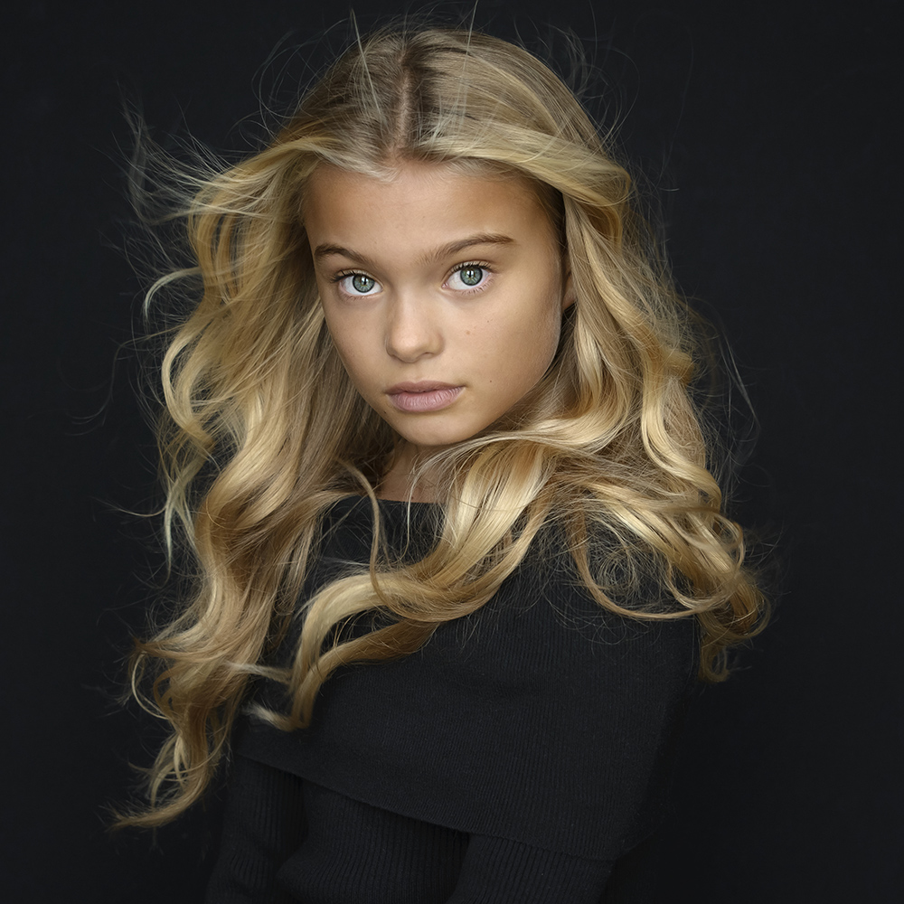 Kleur portret van blond meisje met groene ogen genomen in studio met windmachine en daglicht.jpg