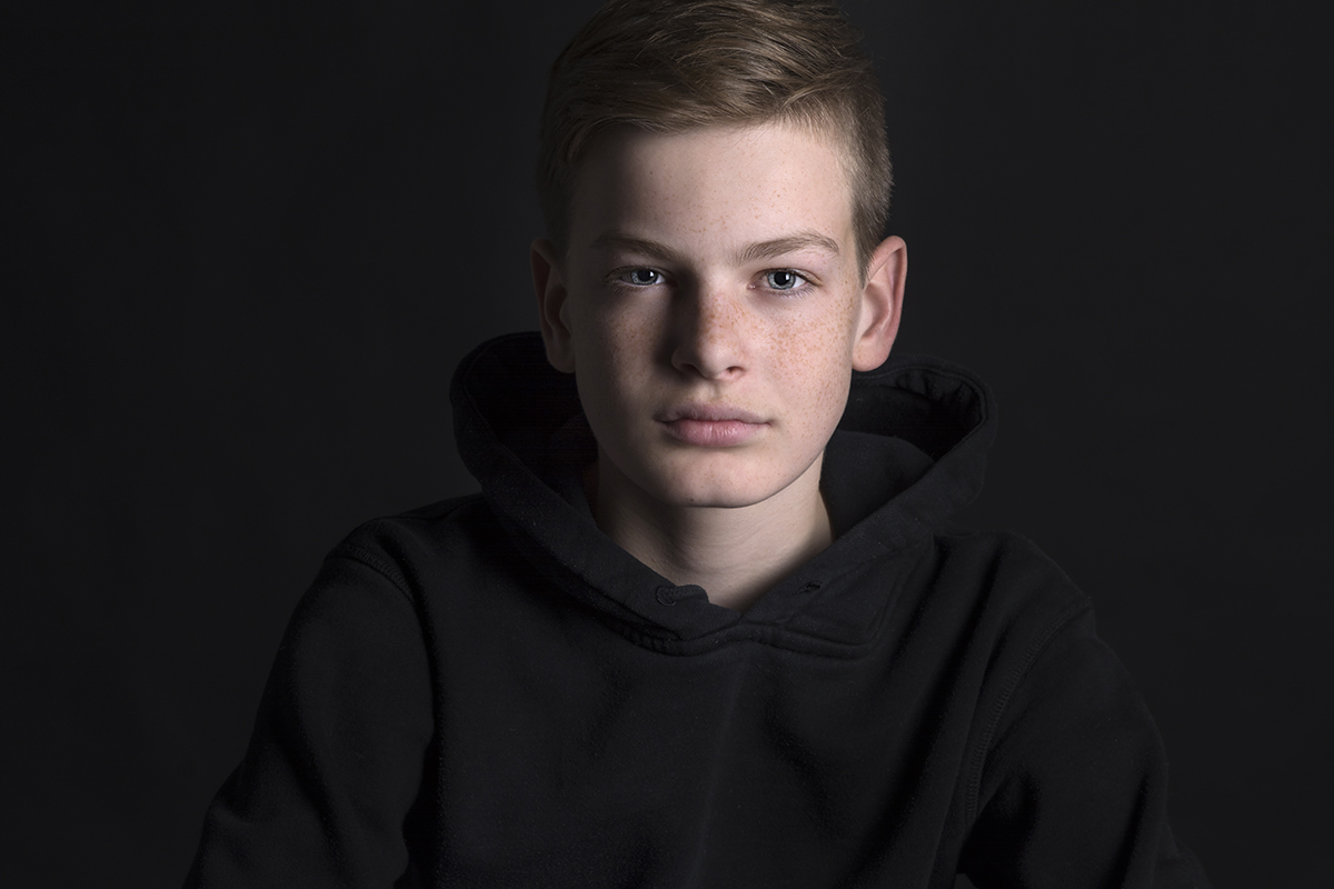 Portret tiener jongen met rood haar sproetjes en blauwe ogen genomen met Nikon in fotostudio.jpg