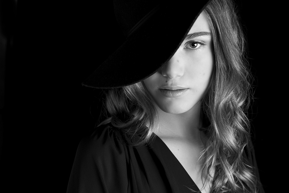 Zwartwit portret van jonge dame met zwarte hoed genomen tijdens fotoshoot in studio Loosdrecht met Nikon D850.jpg