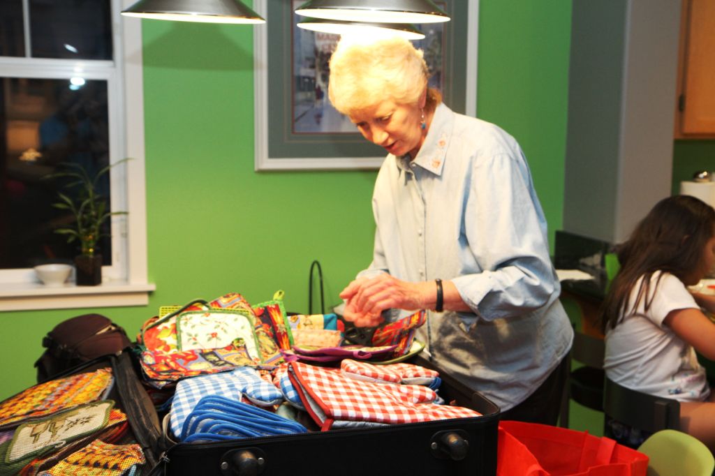 Team member Diane Malone packs pot holders to be given as gifts to those who receive a stove.