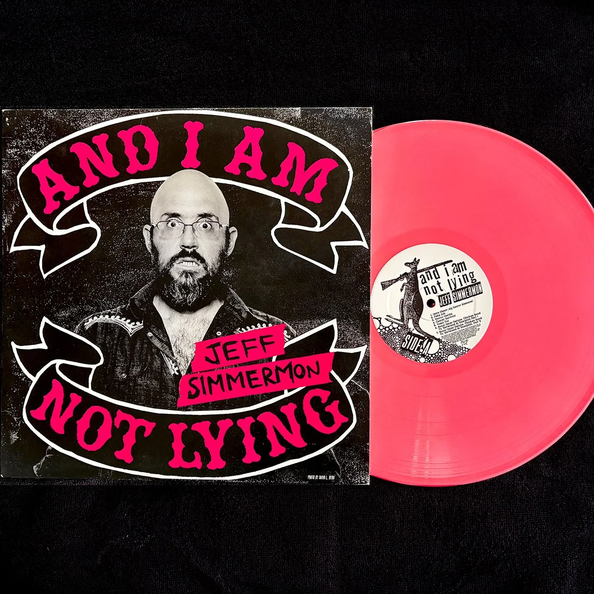 Hot-pink vinyl edition of Jeff Simmermon’s album And I Am Not Lying displayed beside its black, white and pink album cover.