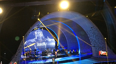 Pointing to herself as a "Survivor", Adrienne Slaughter appears on video screen behind LIVE performance by Jennifer Hudson, Common and Lupe Fiasco at Stand Up To Cancer Telethon at the Dolby Theater on September 5, 2014.