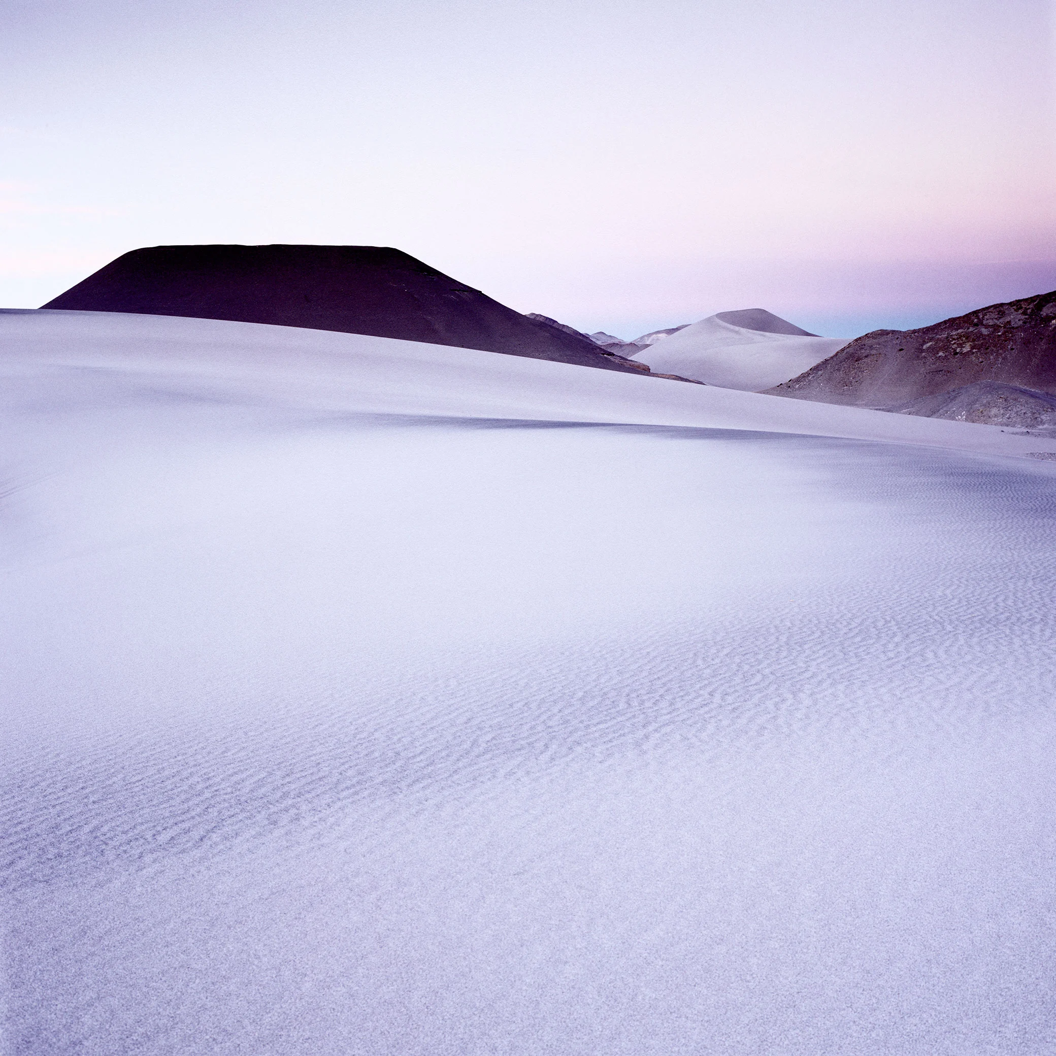 Global contrast applied: Everything is 'hard-toned', and my eye is jumping from the black volcano to the sand in the foreground and then to the hill on the far right-hand-side. My eye is being pulled everywhere.