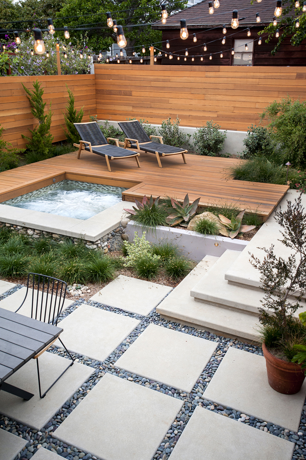 modern backyard with wood deck, fence and spa