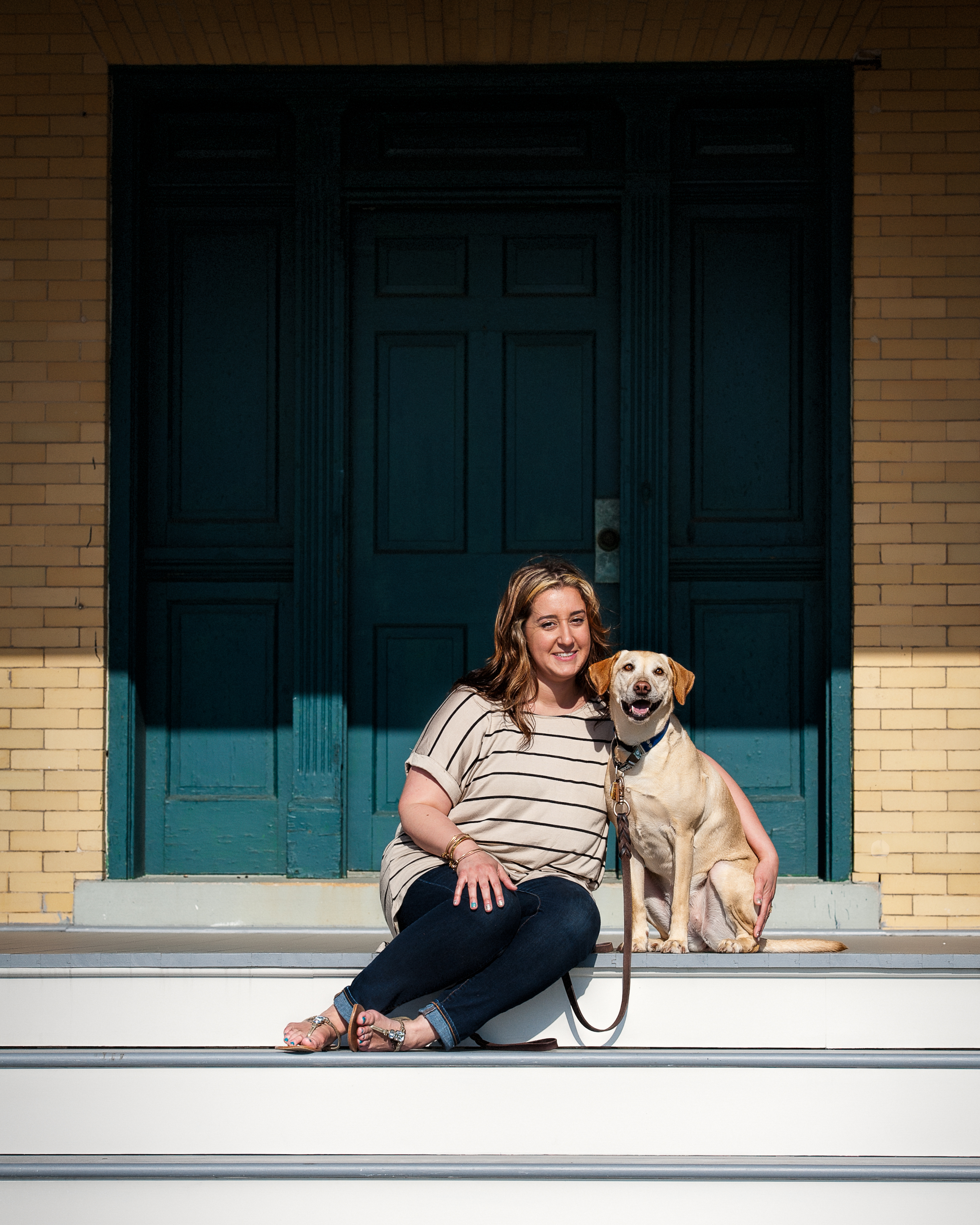 Young lady with her dog sitting on steps on the barracks at Sandy Hook, New Jersey