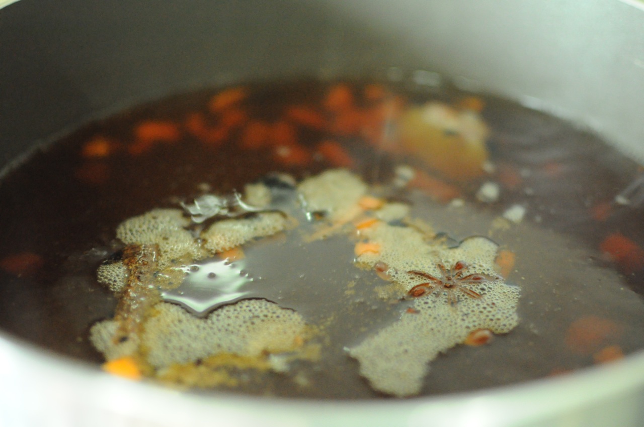 Boiling the carrots, onions, ginger along with the spices on a low flame for a couple of hours