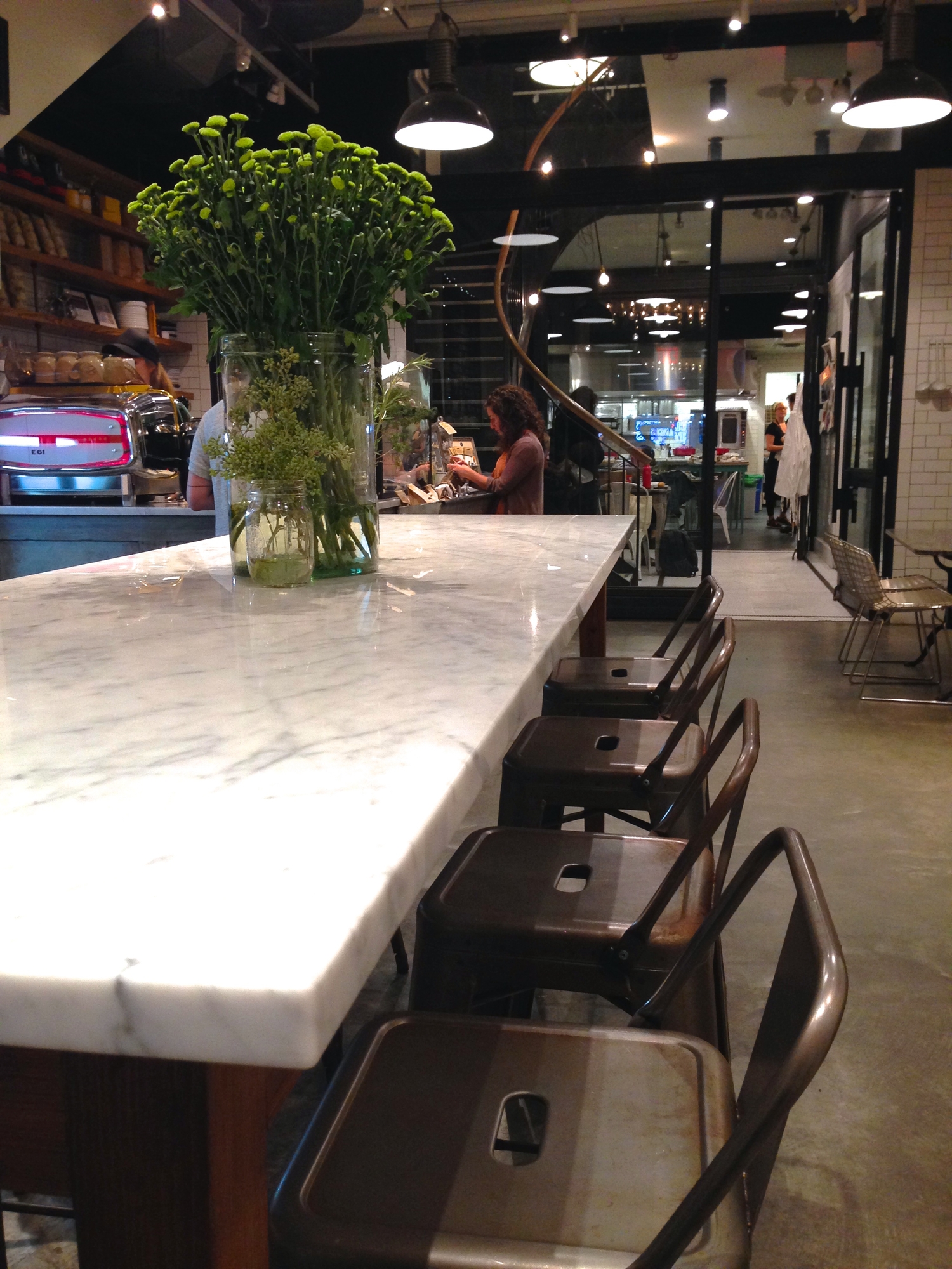  View from the cafe, ktchen toward the back. I would like to steal this marble high-top and the chairs, please. 