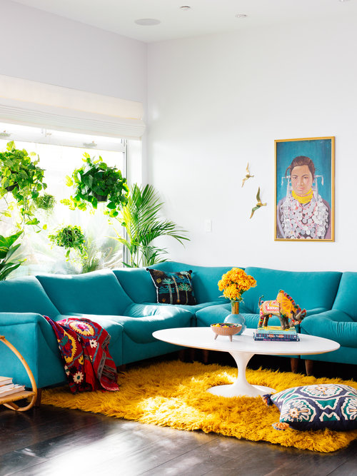 Justina Blakeney design - living room with teal couch, yellow shag rug, and a white tulip coffee table