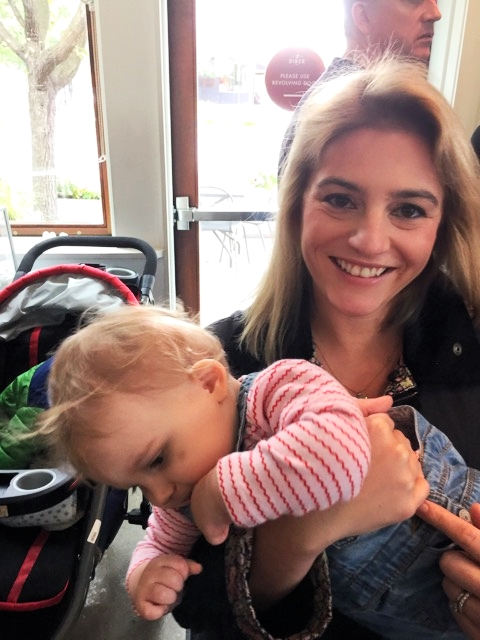 Tabby trying to wiggle out of my arms in front of the “stroller parking”. The bruise on her cheek is from an unfortunate encounter with a maraca at day care
