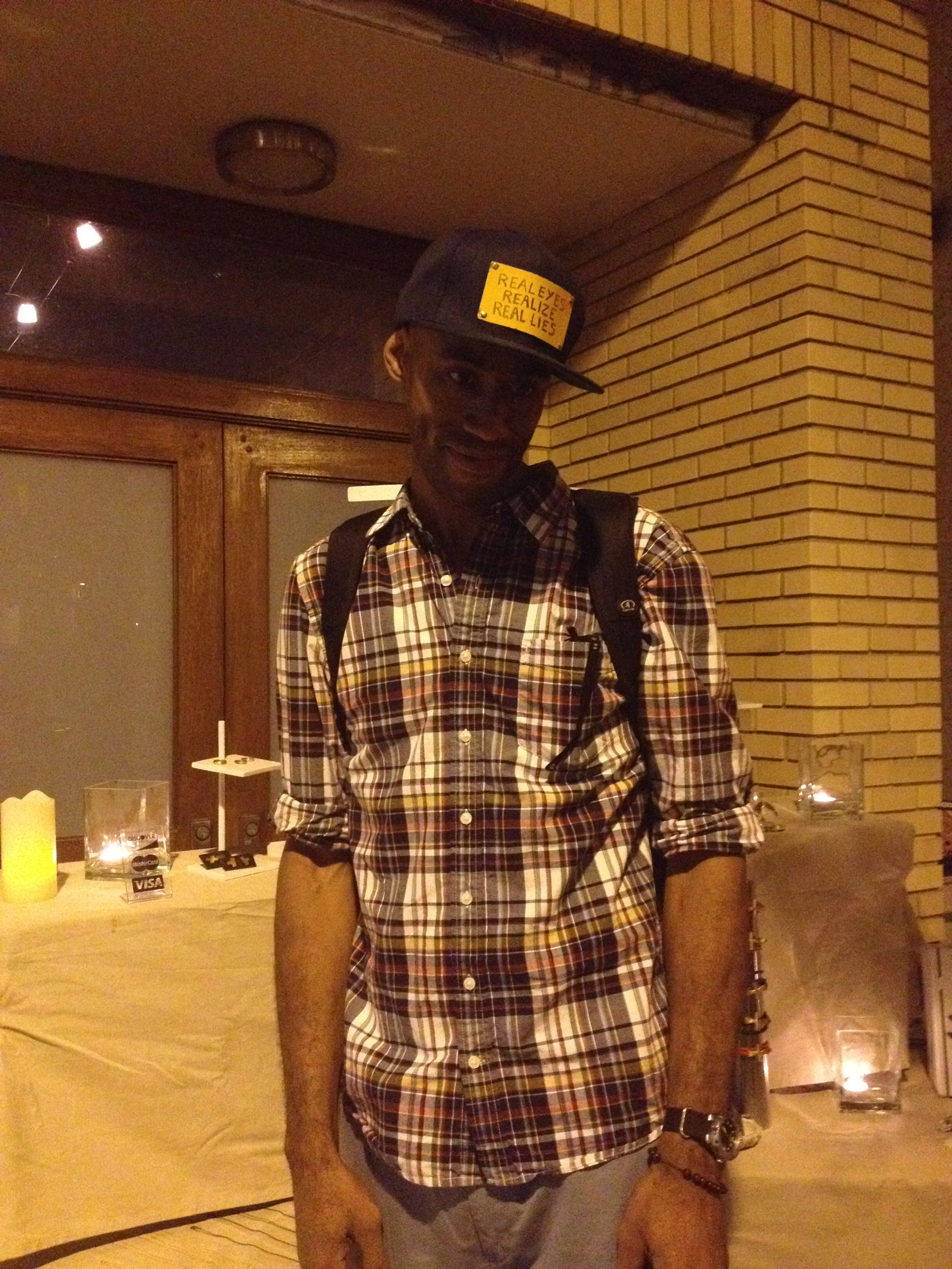  JARED SLOAN KNOWS THAT "REAL EYES REALIZE REAL LIES" AND HE HAS ONE OF FEW CUSTOM-MADE HATS TO SHOW IT 