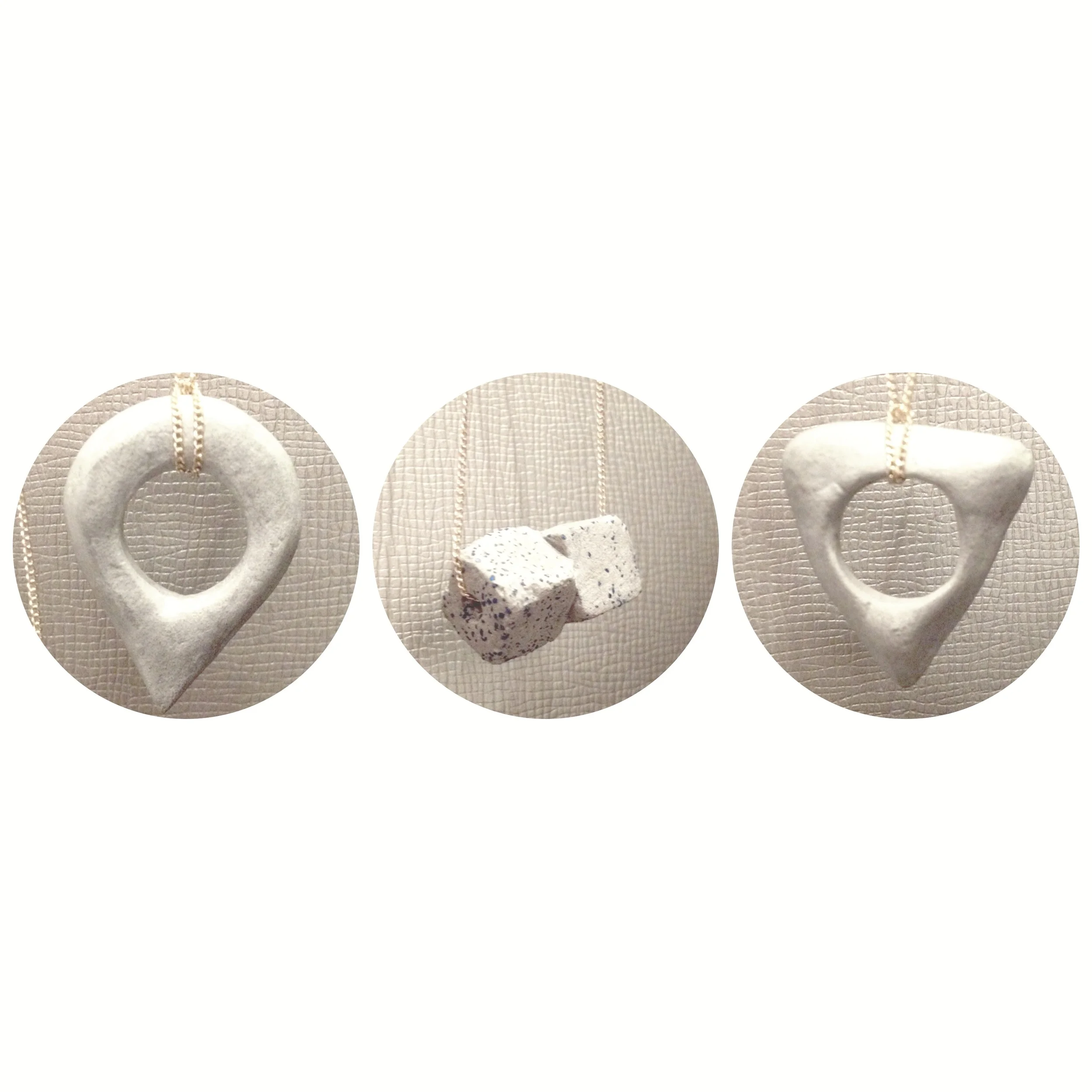 Our newest concrete pendants. From left: You Are Here , Cubic Kiss , & Ouija necklaces.