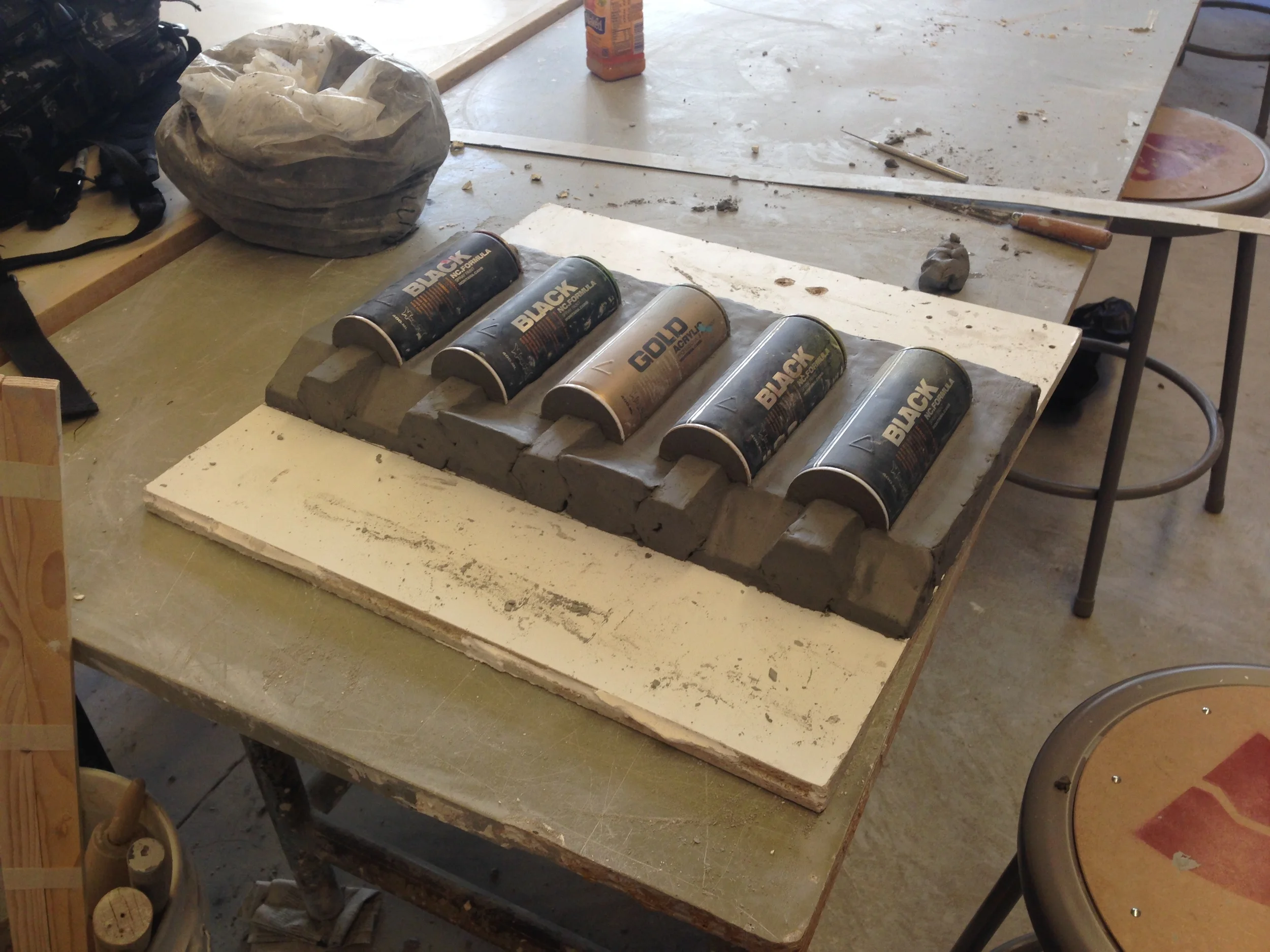  To make a mold, you build clay up to the half-way divider of your object, surround everything with a wooden frame, pour plaster and let dry, turn everything over and remove the clay, and finally, pour plaster on the other side. 
