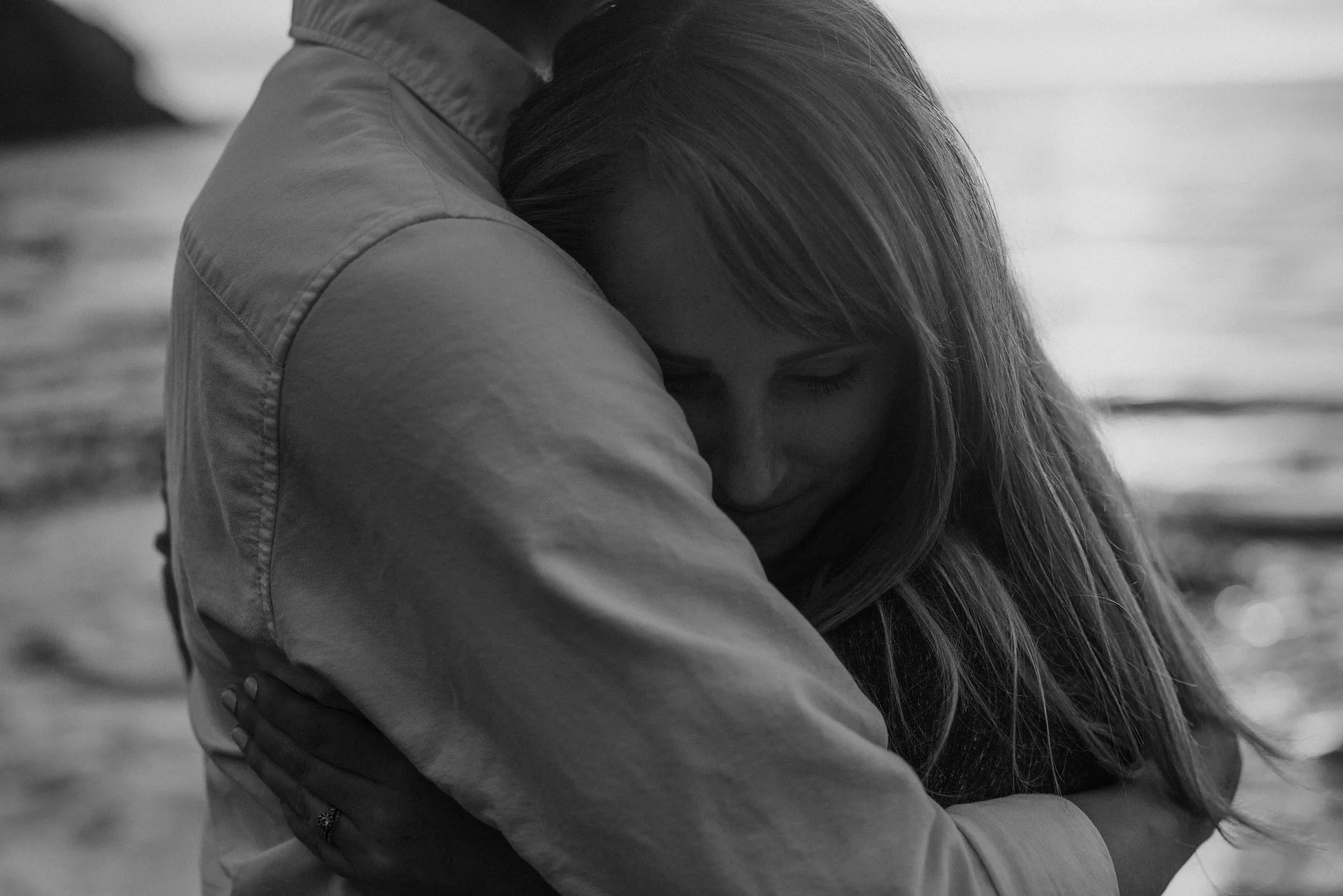 Couple snuggled at the ocean.