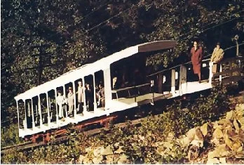 A rare color view of the cars passing on the turnout, circa 1950s. Notice that the summit-facing sides of each car was elongated, able to carry cargo and supplies to the mountaintop. The rear car was rebuilt without a roof after burning in 1936.