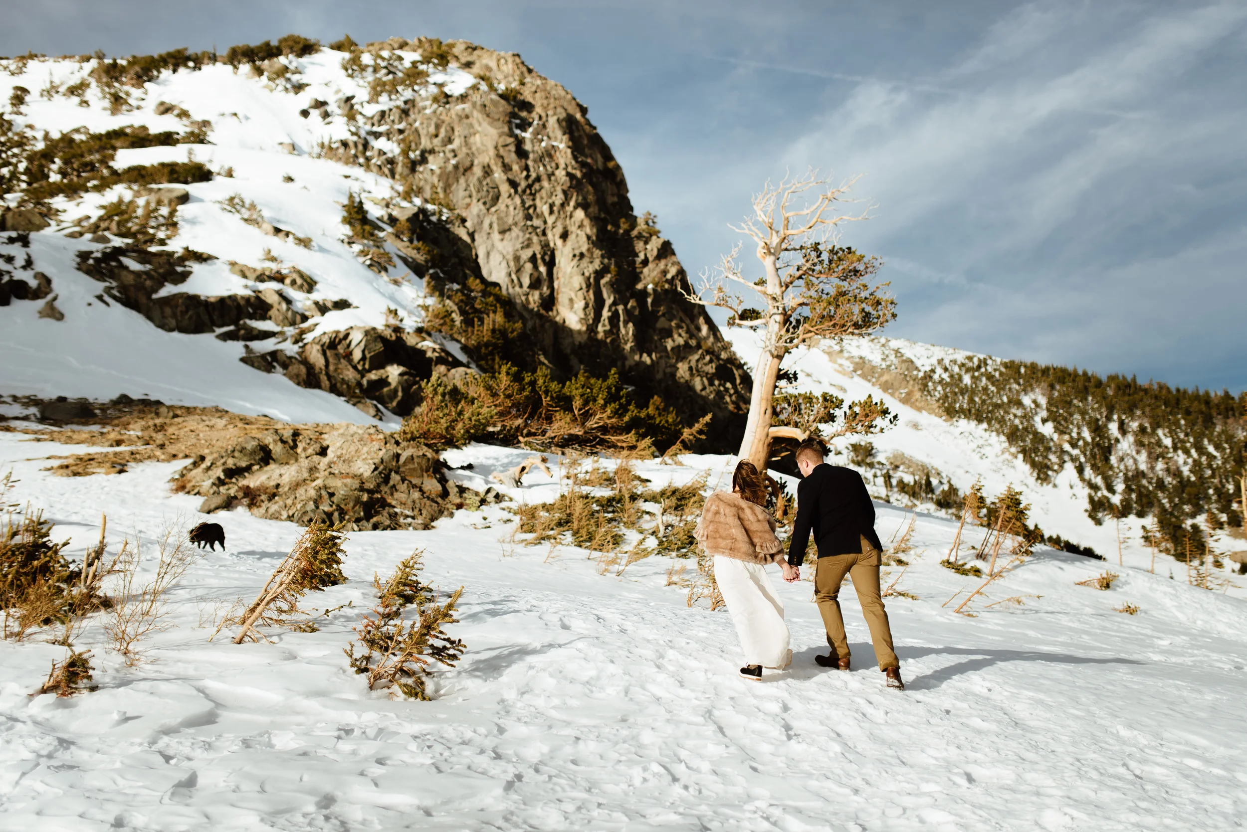 Kelsie and Tyler are on their way up to the romantic and intimate ceremony spot. I love the wild and whimsical snowy forest in Idaho Springs, Colorado. | Mountain elopement pictures by intimate wedding photographer, Maddie Mae.