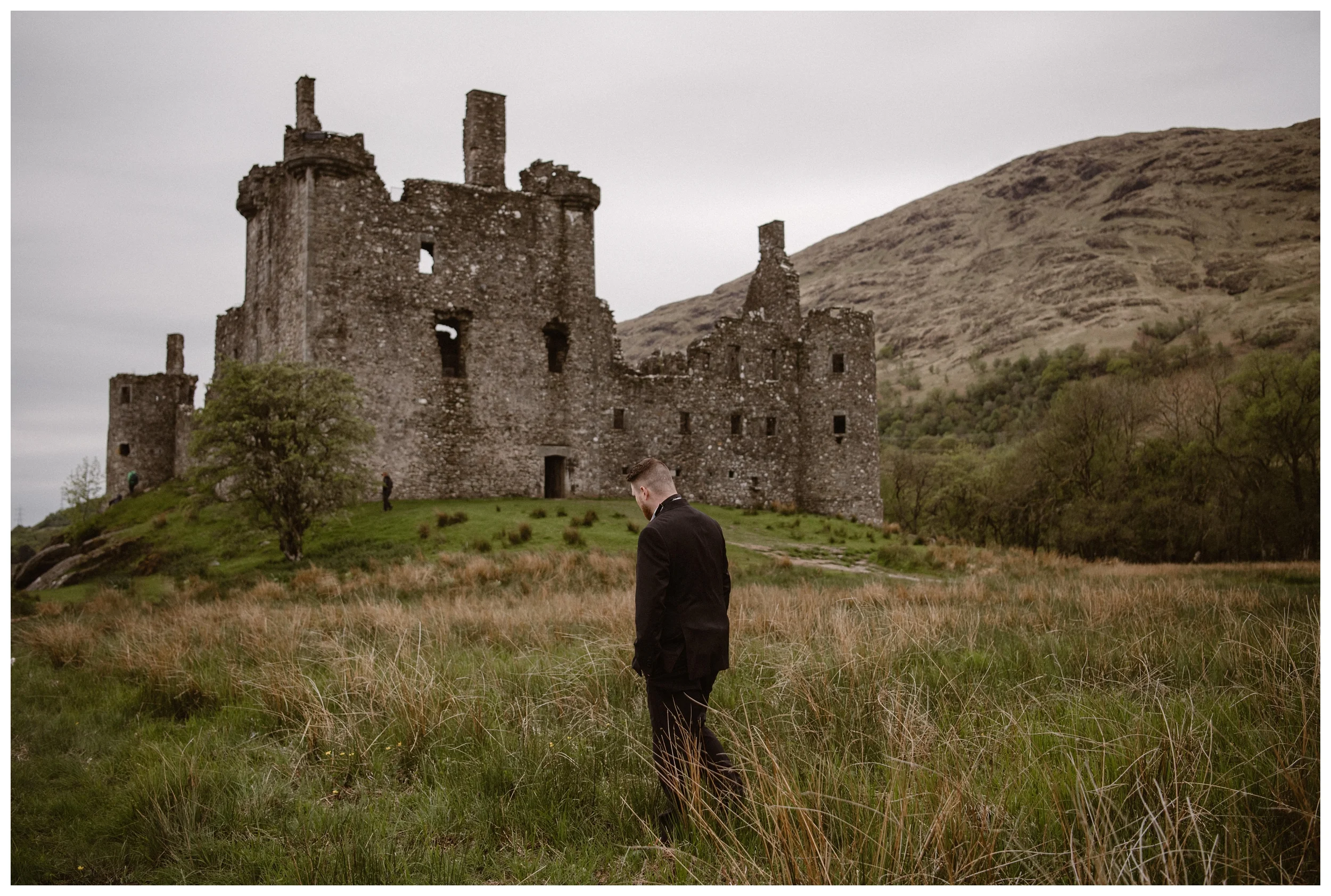 Daniel waits for his bride Elissa before their private first look at Kilchurn Castle in the Scottish Highlands. Photo by Maddie Mae, Adventure Instead.