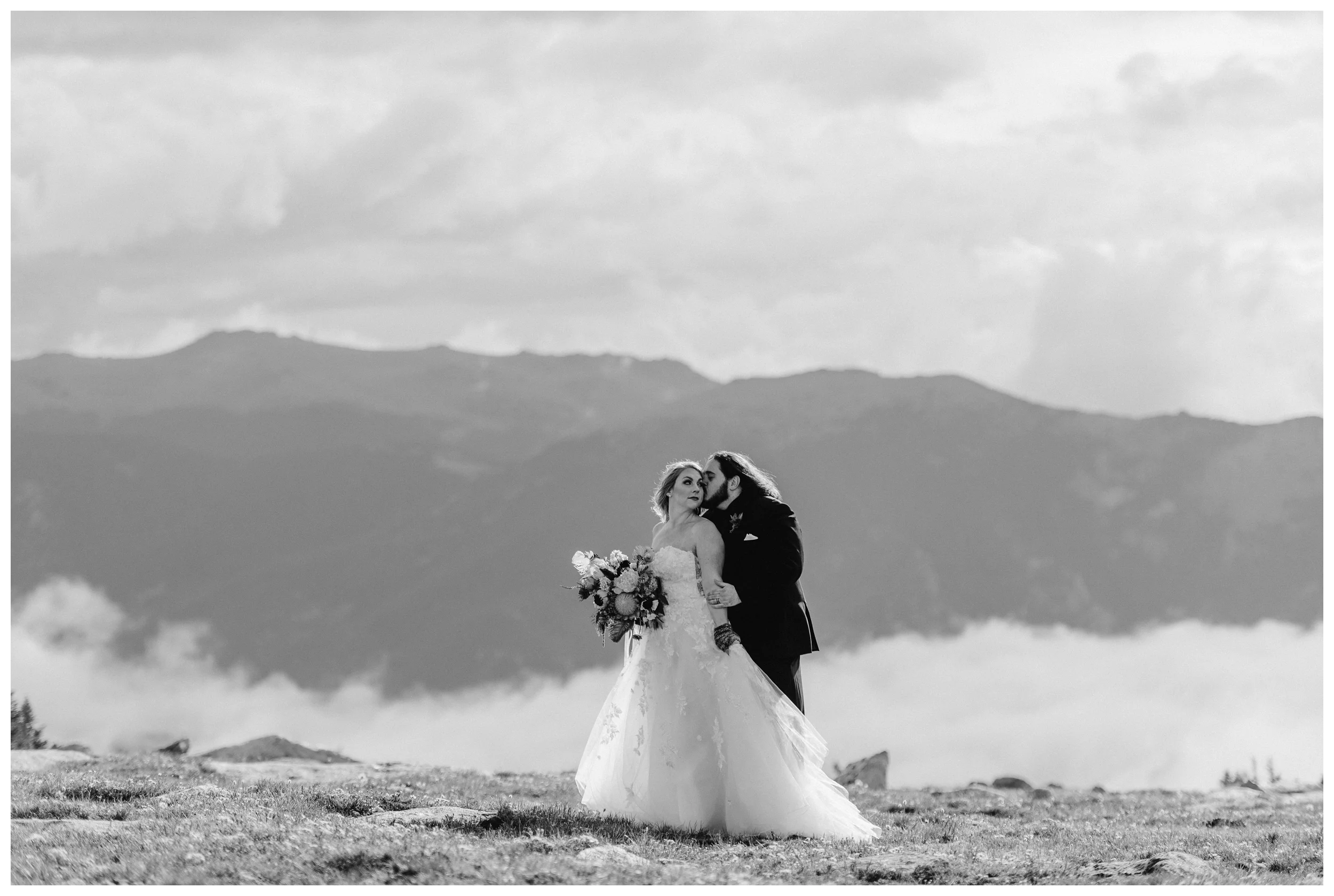 Alicia and Zach embrace while the clouds show off an impressive display of cloud inversion during their first look at Trail Ridge Road in Rocky Mountain National Park. Photo by Adventure Instead, Maddie Mae.