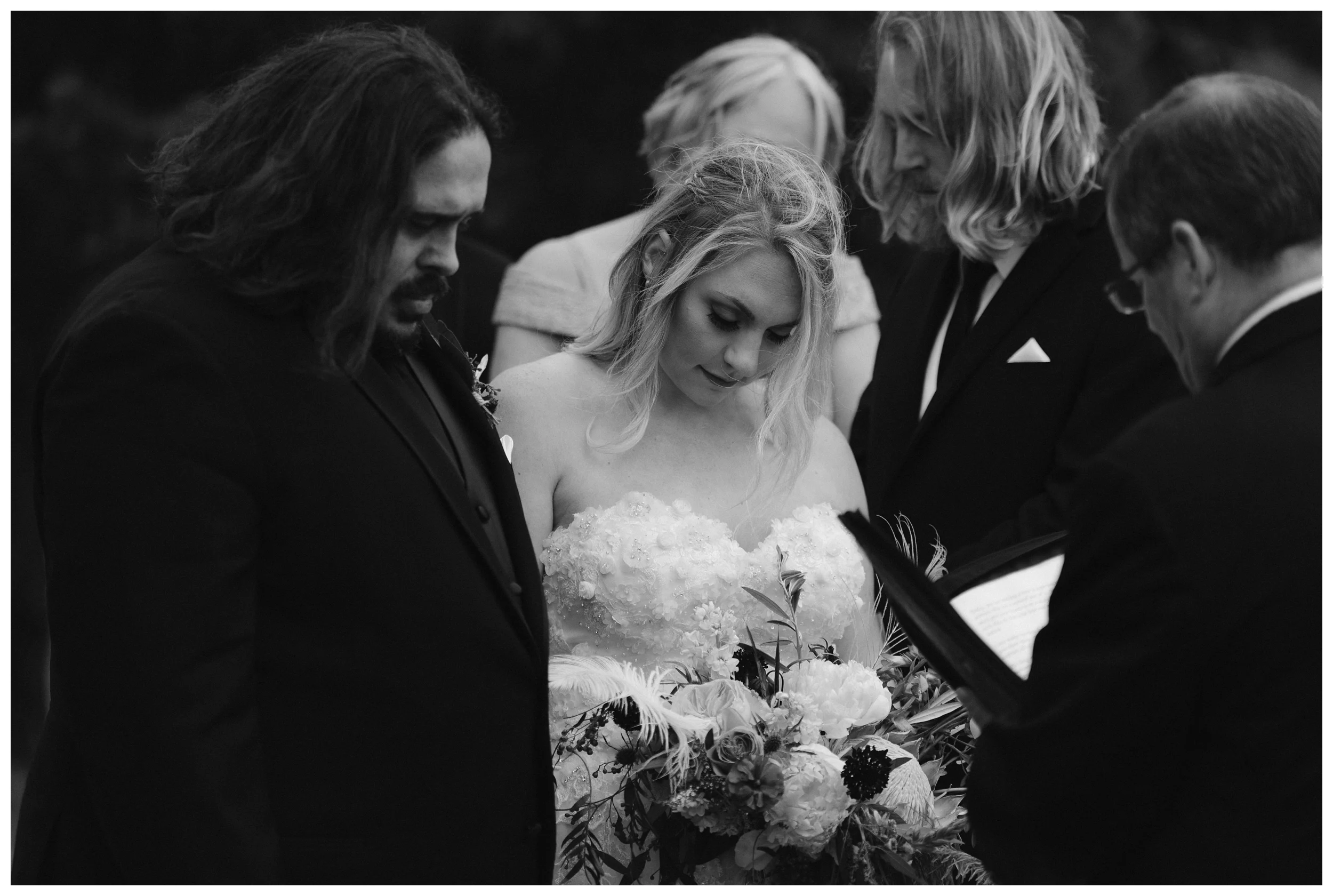 Alicia and Zach bow their heads in prayer led by their officiant during their intimate elopement ceremony in Rocky Mountain National Park, Estes Park, Colorado. Photo by Adventure Instead, Maddie Mae.