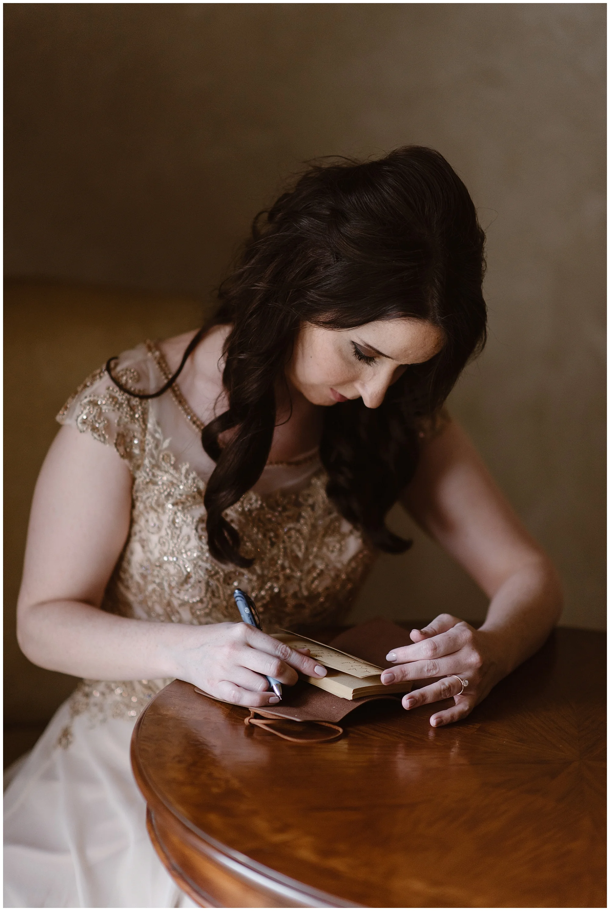 Marlayna writes out her wedding vows by hand before her elopement ceremony at the snowy Sapphire Point in Dillon, Colorado. Photo by Adventure Instead, Maddie Mae Elopement Photographers.