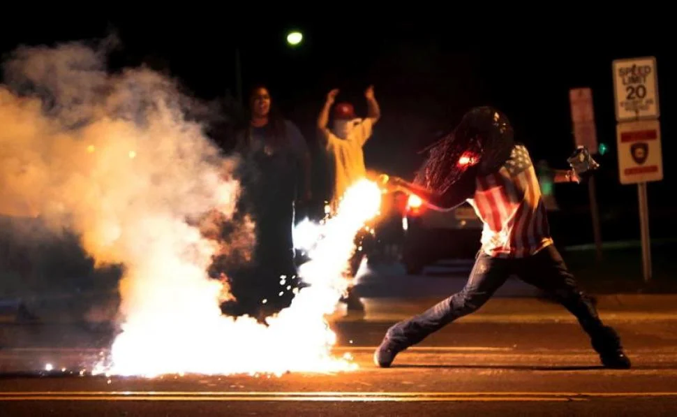 Protestors in Ferguson returning a tear gas container after tactical officers attempt to break up a group of bystanders, Aug. 14, 2014 in Ferguson, MO. 