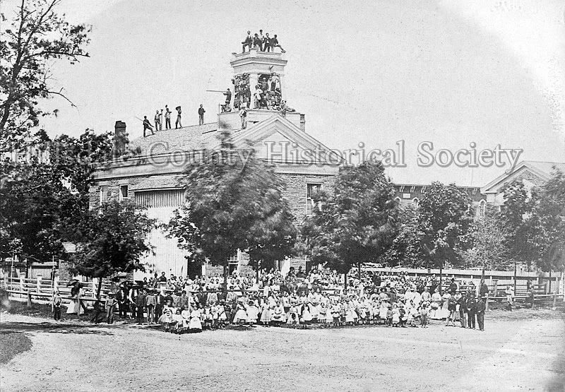 Stone School on Courthouse Square on "Moving Day," when everyone helped to carry materials to the new Central School, where Bailey Elementary now stands.