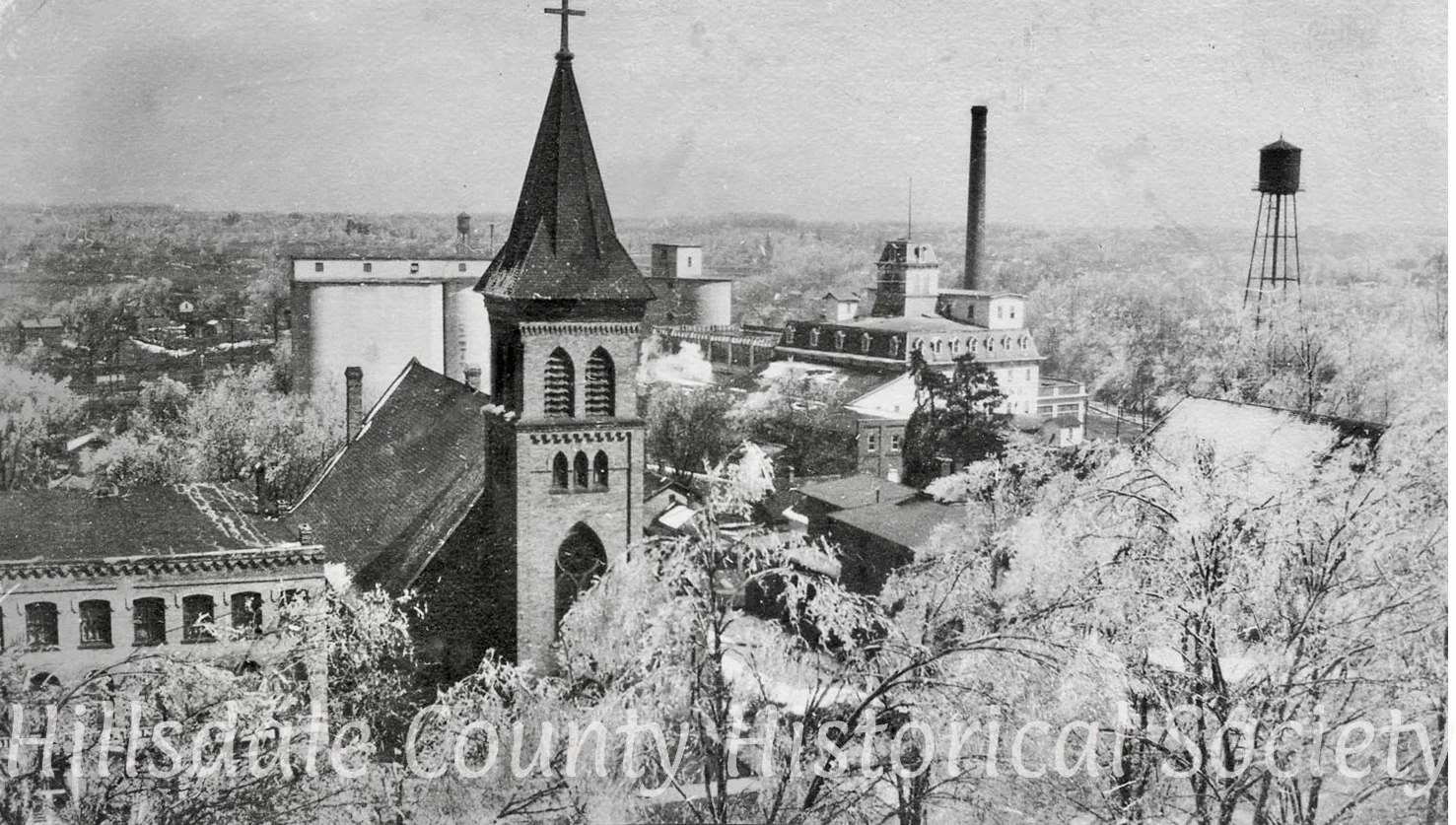 The grand steeple of St. Anthony's Catholic Church. In the background is Stock's Mill before renovation, with the water towere across the street in the park.